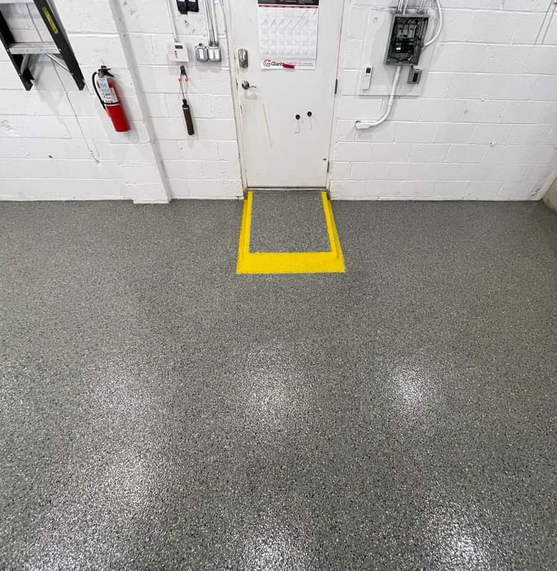A yellow area demarks where a rise in the flooring occurs, a custom touch the customer asked for in this epoxy flooring pour.