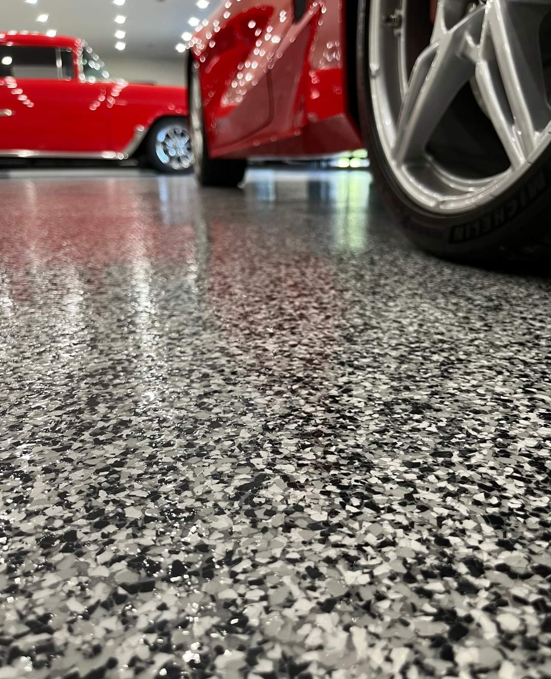The same garage with epoxy floors, it has cured enough for the cars to be parked inside.
