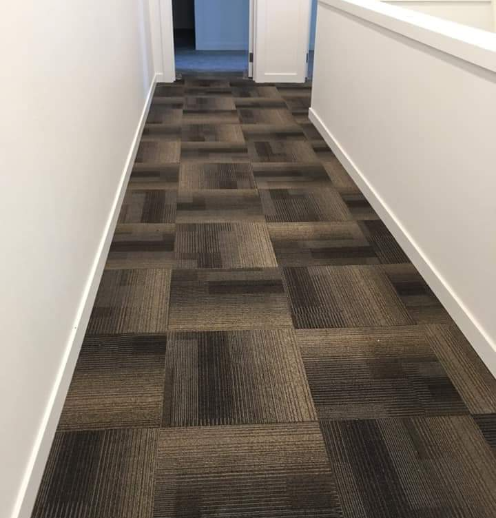 Geometric carpet tiles are completely installed in this shared office space.