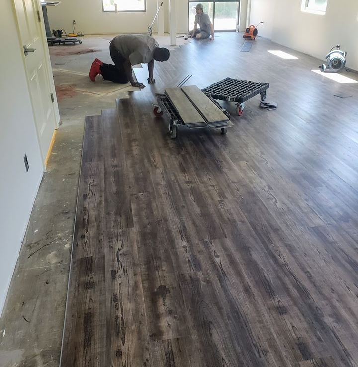Some of our crew laying down pre-engineered hardwood flooring.