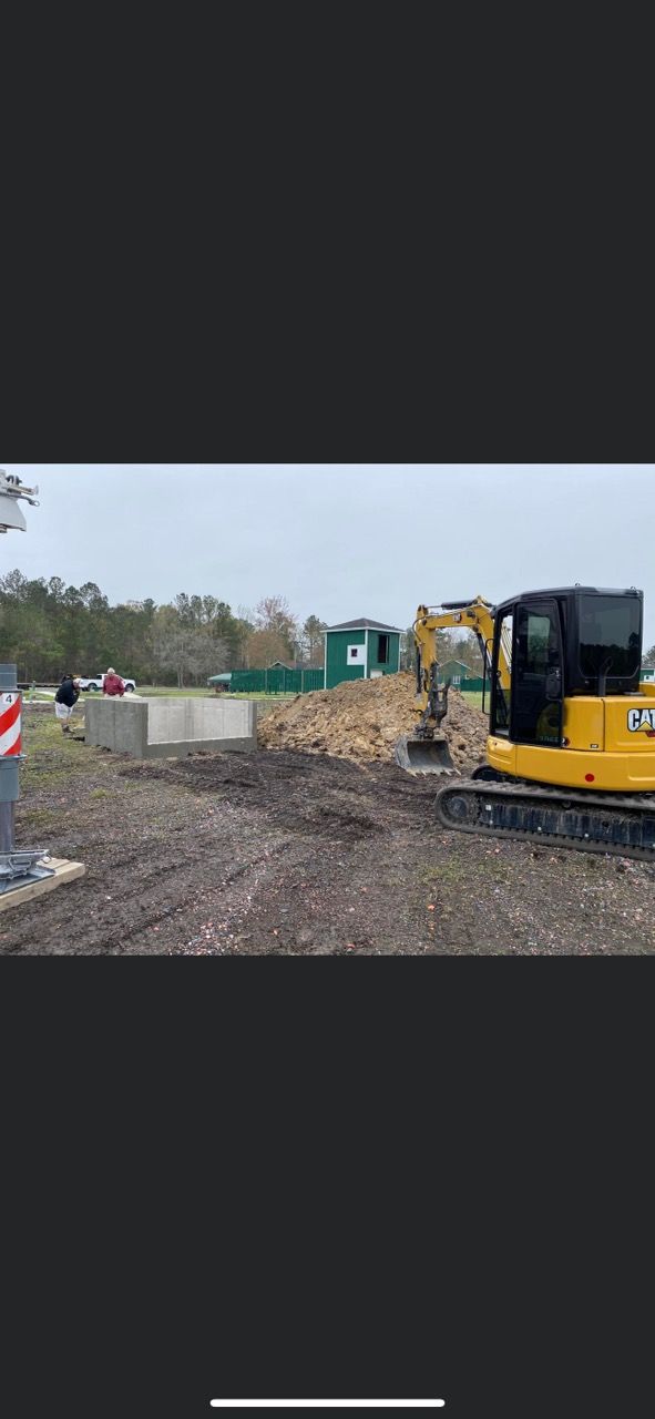 a yellow excavator is digging a large pile of dirt in a construction site .