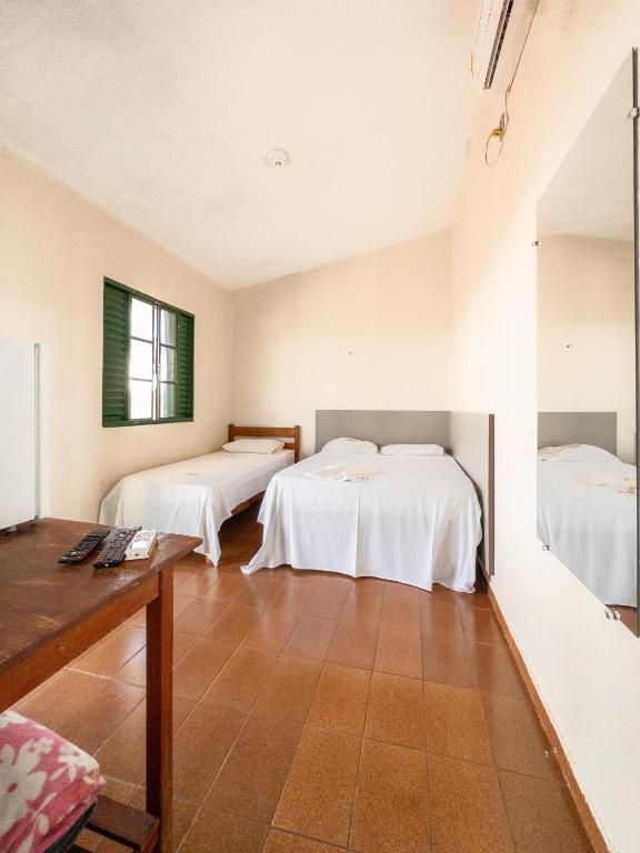 Um quarto com duas camas e um espelho na parede