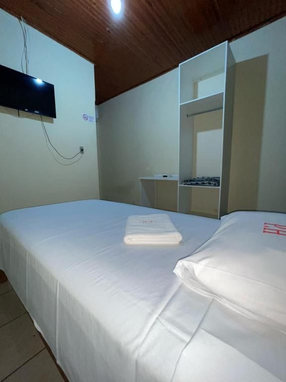 Um quarto de hotel com uma cama e uma TV de tela plana