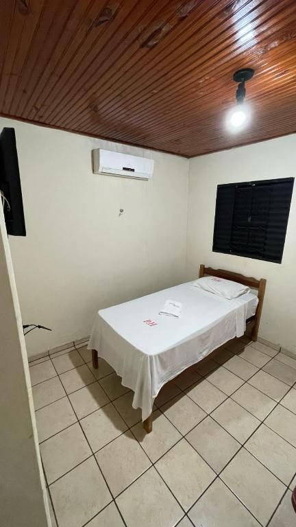 Um quarto com uma cama de solteiro e uma televisão.