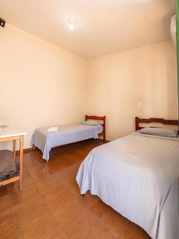 Um quarto com duas camas e uma mesa