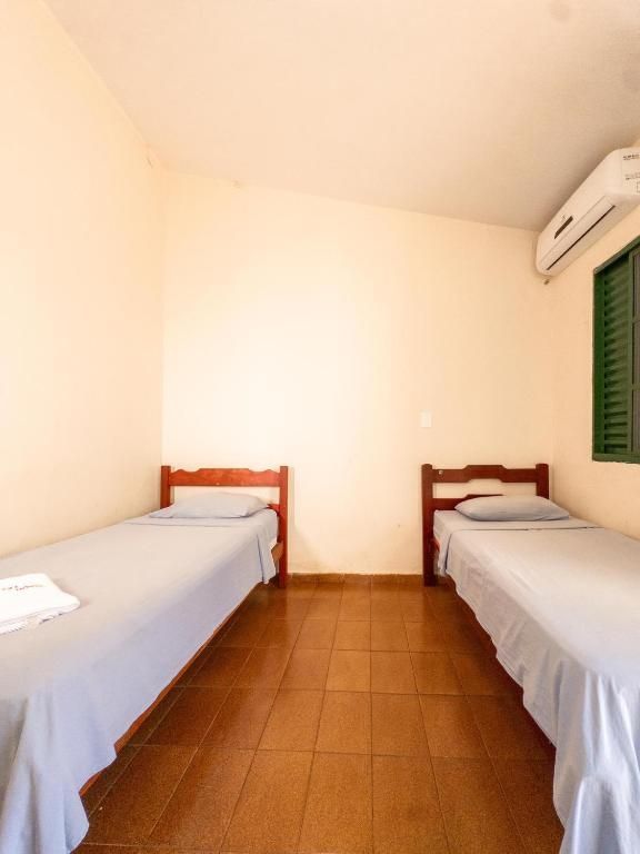 Um quarto com duas camas e uma janela