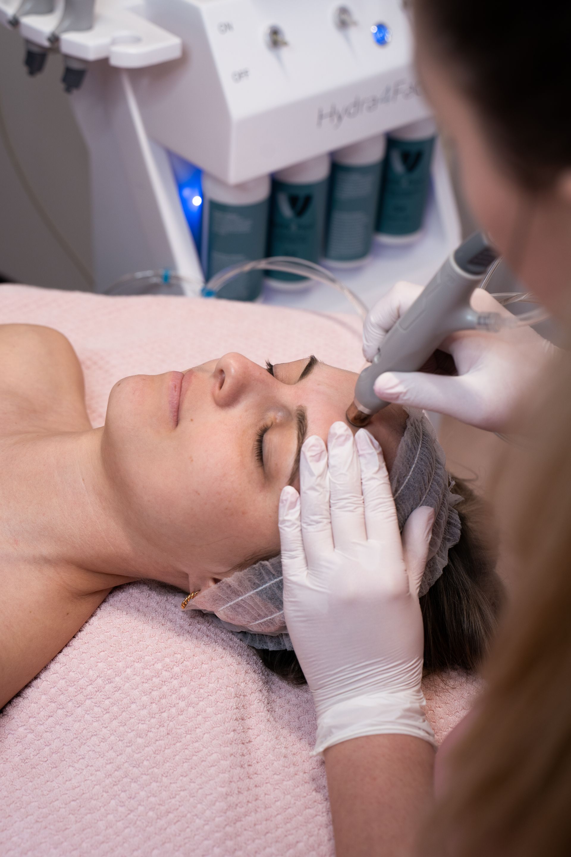 A woman is getting a facial treatment at a beauty salon.