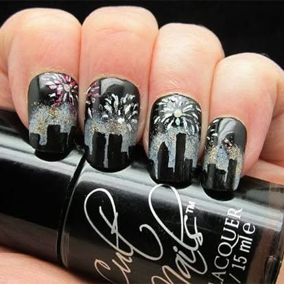 A close up of a person 's nails and a bottle of nail lacquer