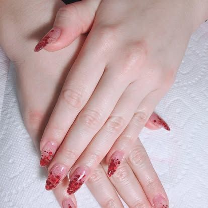 A close up of a woman 's hands with red nails