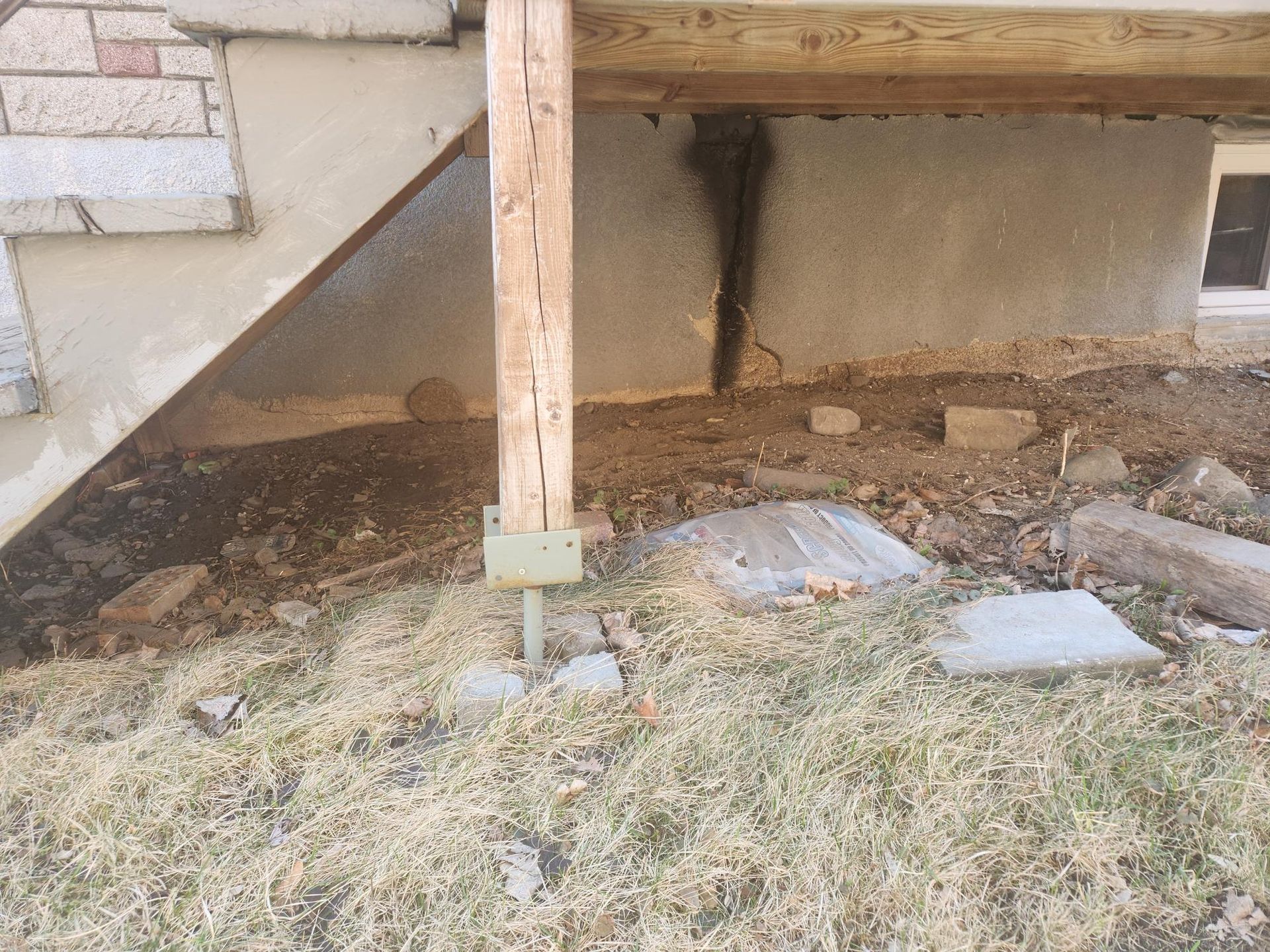 Une terrasse en bois est en cours de construction sous une maison.