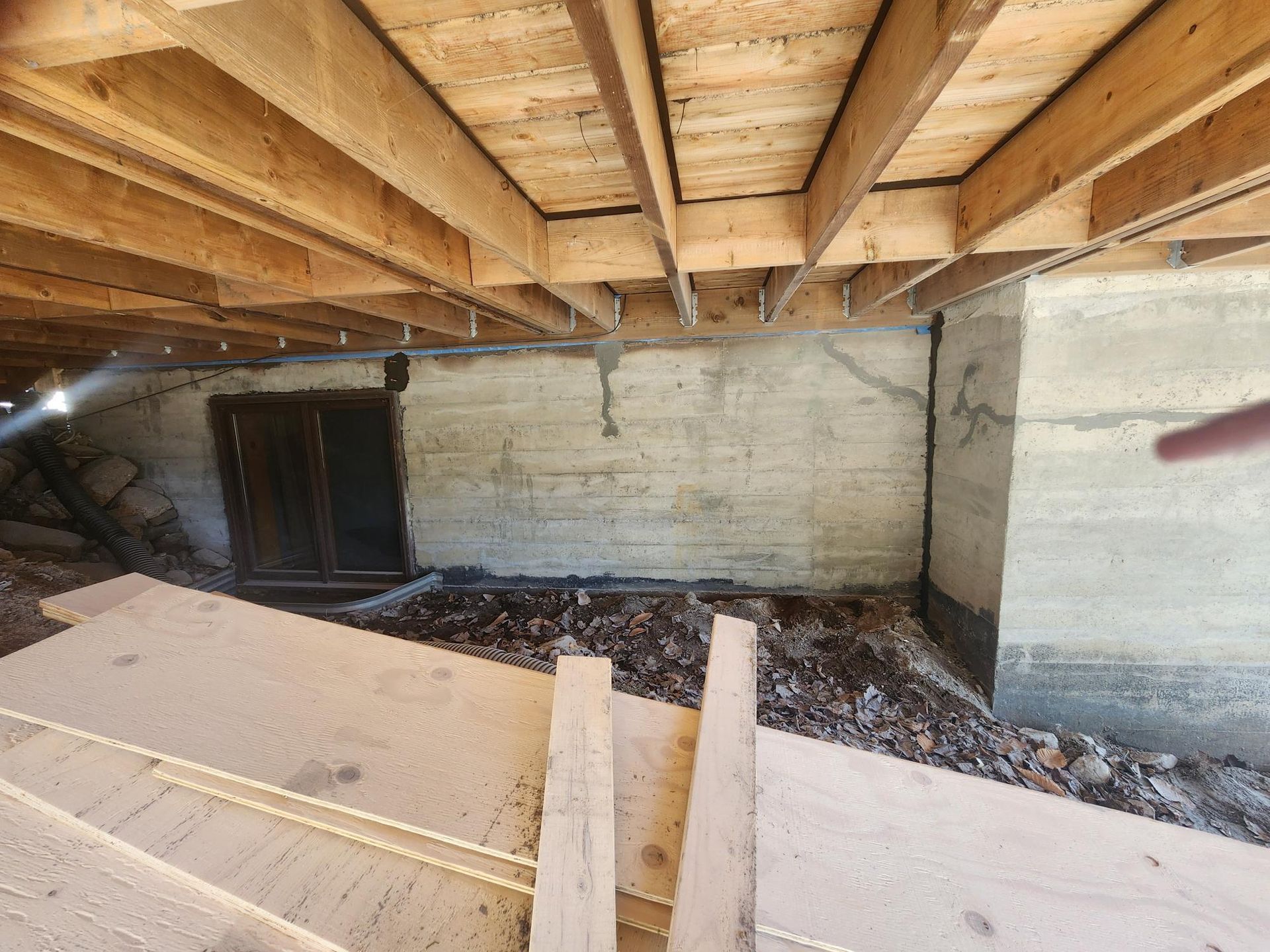 Une personne se tient dans un sous-sol sous un plafond en bois.