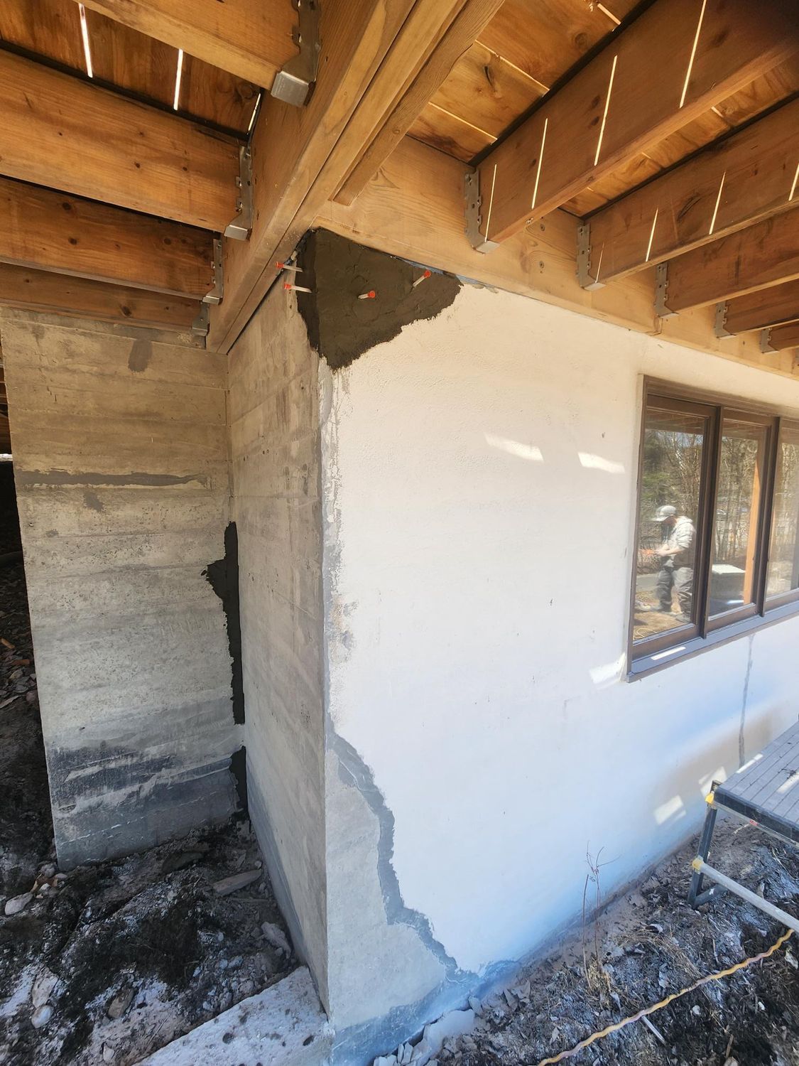 Un coin d'un bâtiment avec un mur en béton et une fenêtre.