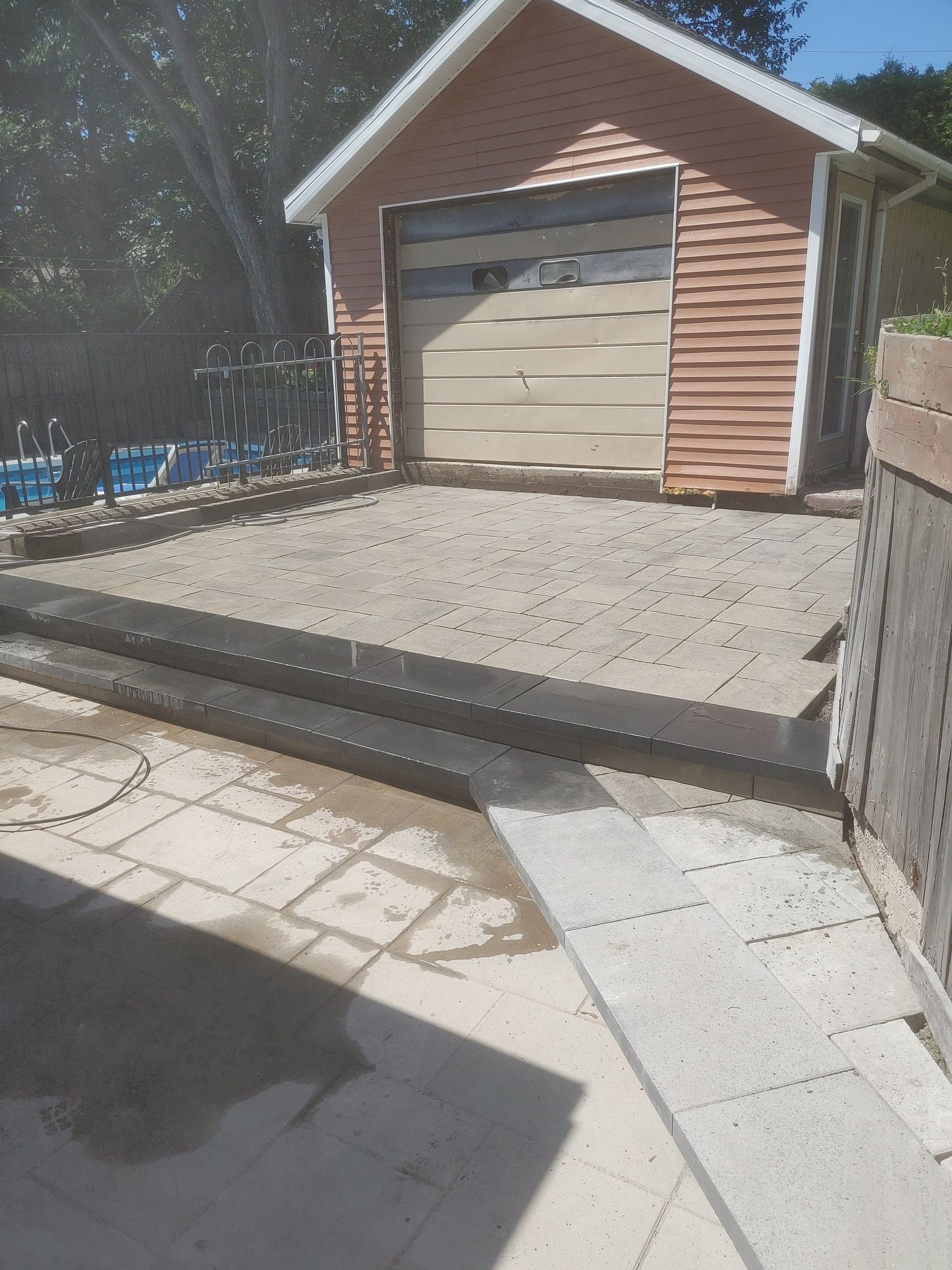 Un garage en briques avec une allée en béton devant