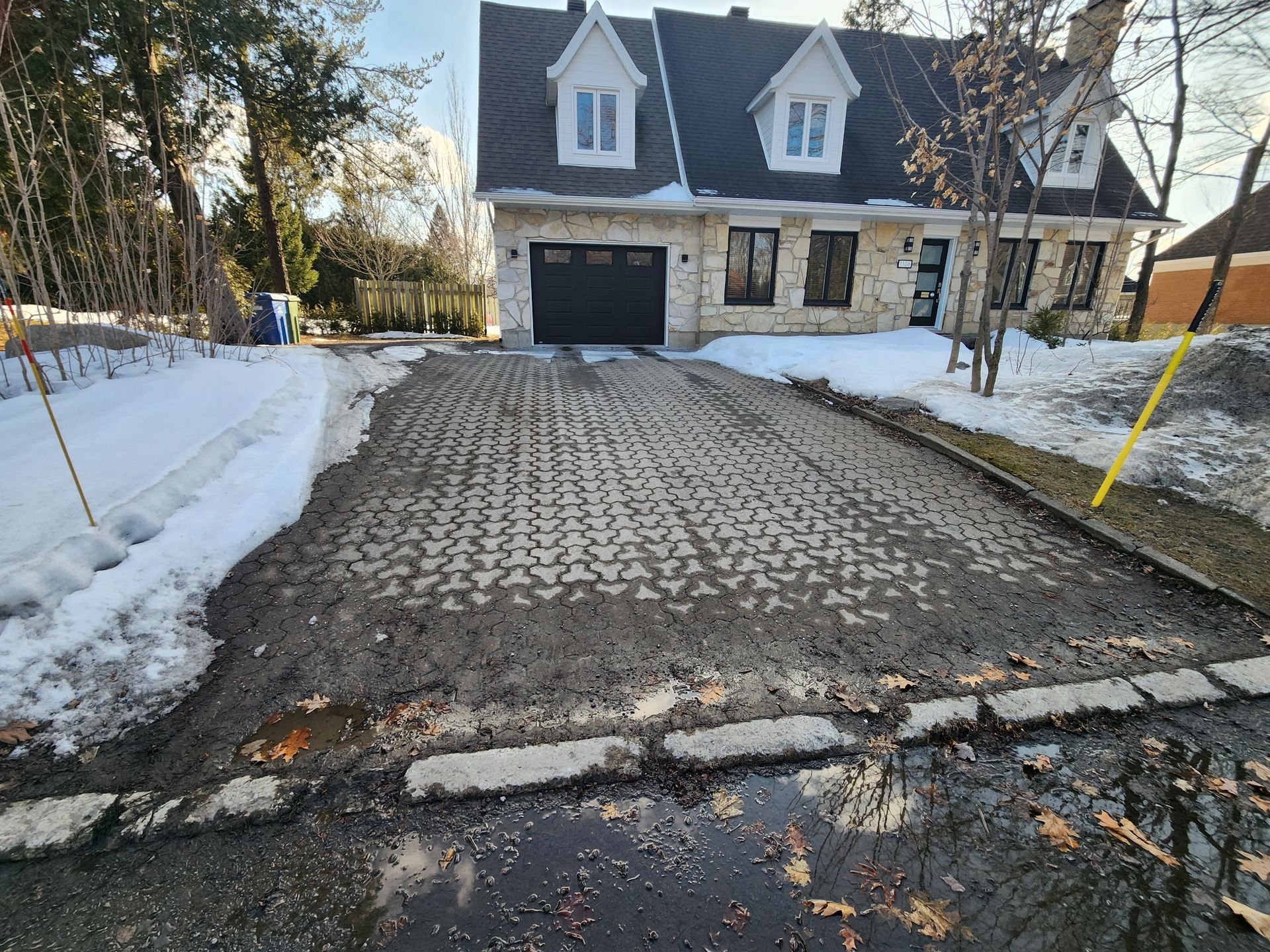 Une grande maison avec une allée recouverte de neige.