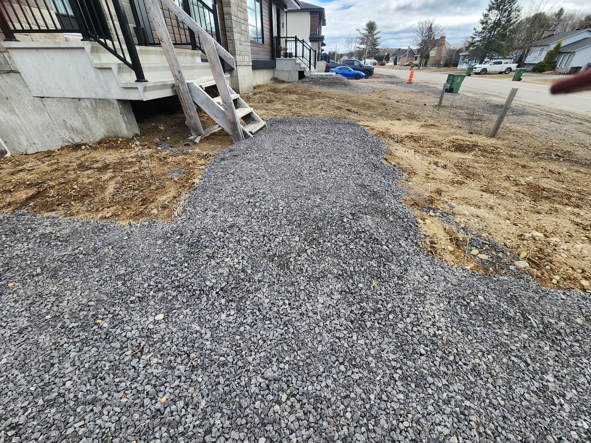 Une allée de gravier est en cours de construction devant une maison.