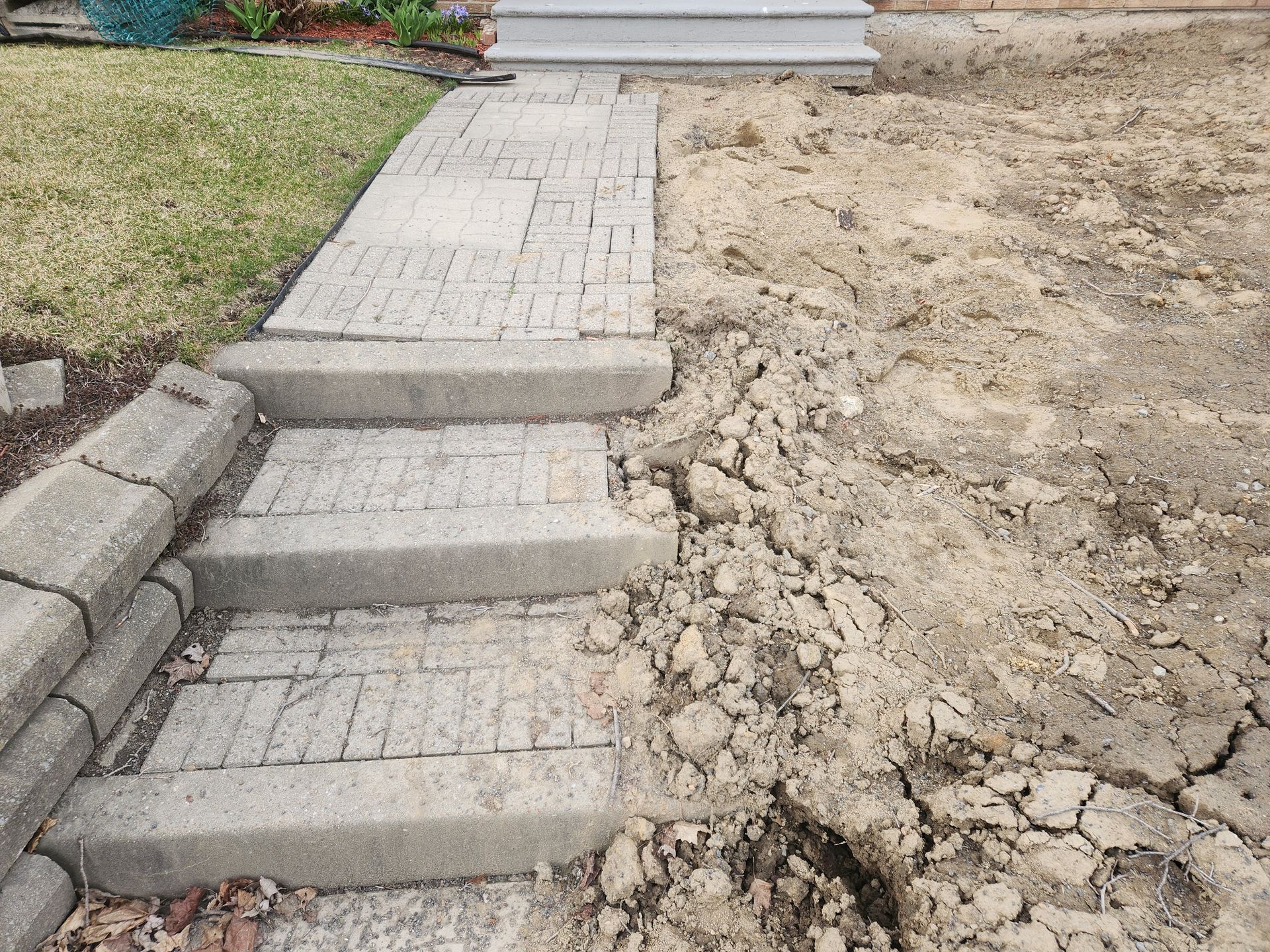 Une passerelle en béton est en train d'être construite dans la terre devant une maison.
