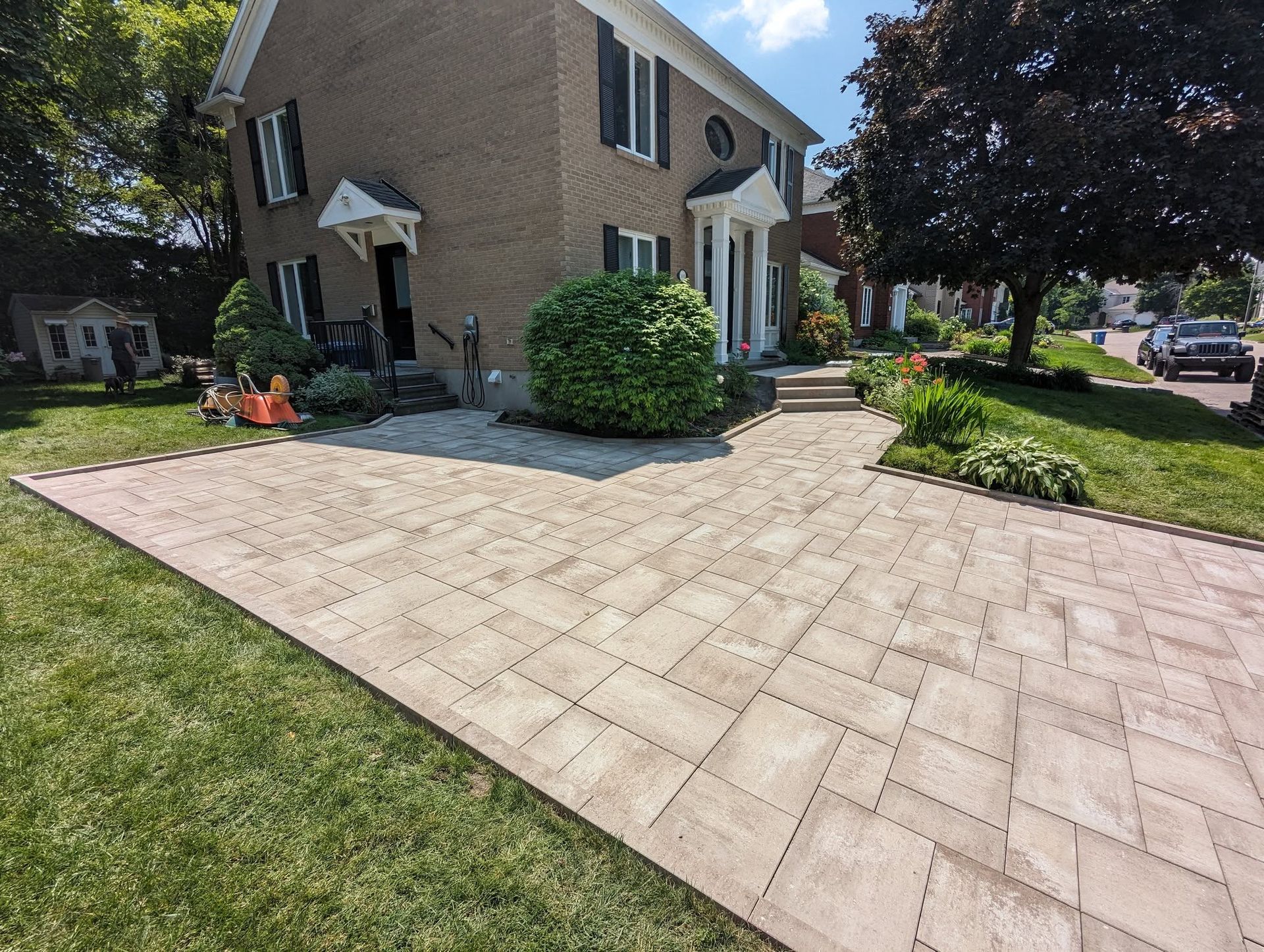 Une grande maison avec une allée en briques devant elle.