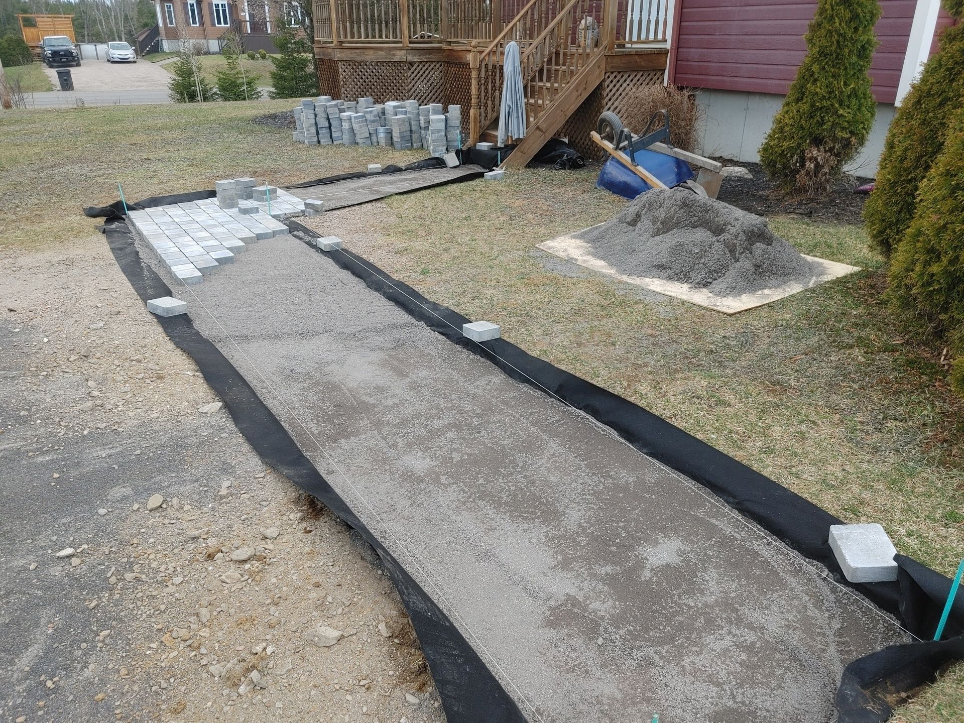 Une passerelle en béton est en cours de construction devant une maison.