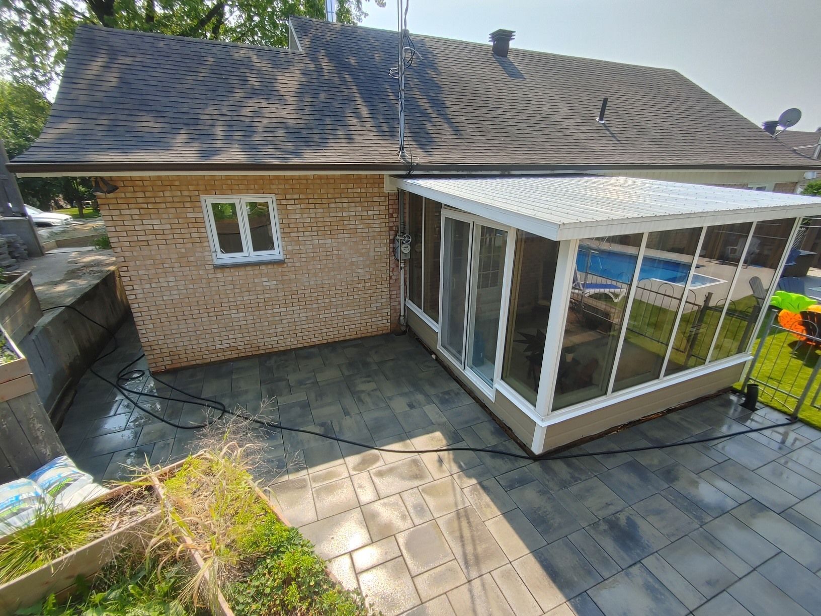 Une maison avec un porche grillagé et une piscine dans l'arrière-cour.