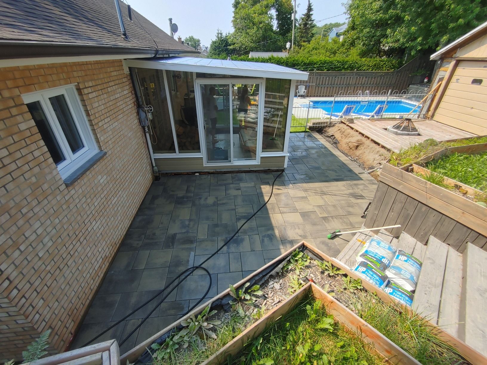 Une maison en briques avec un patio et une piscine dans l'arrière-cour.