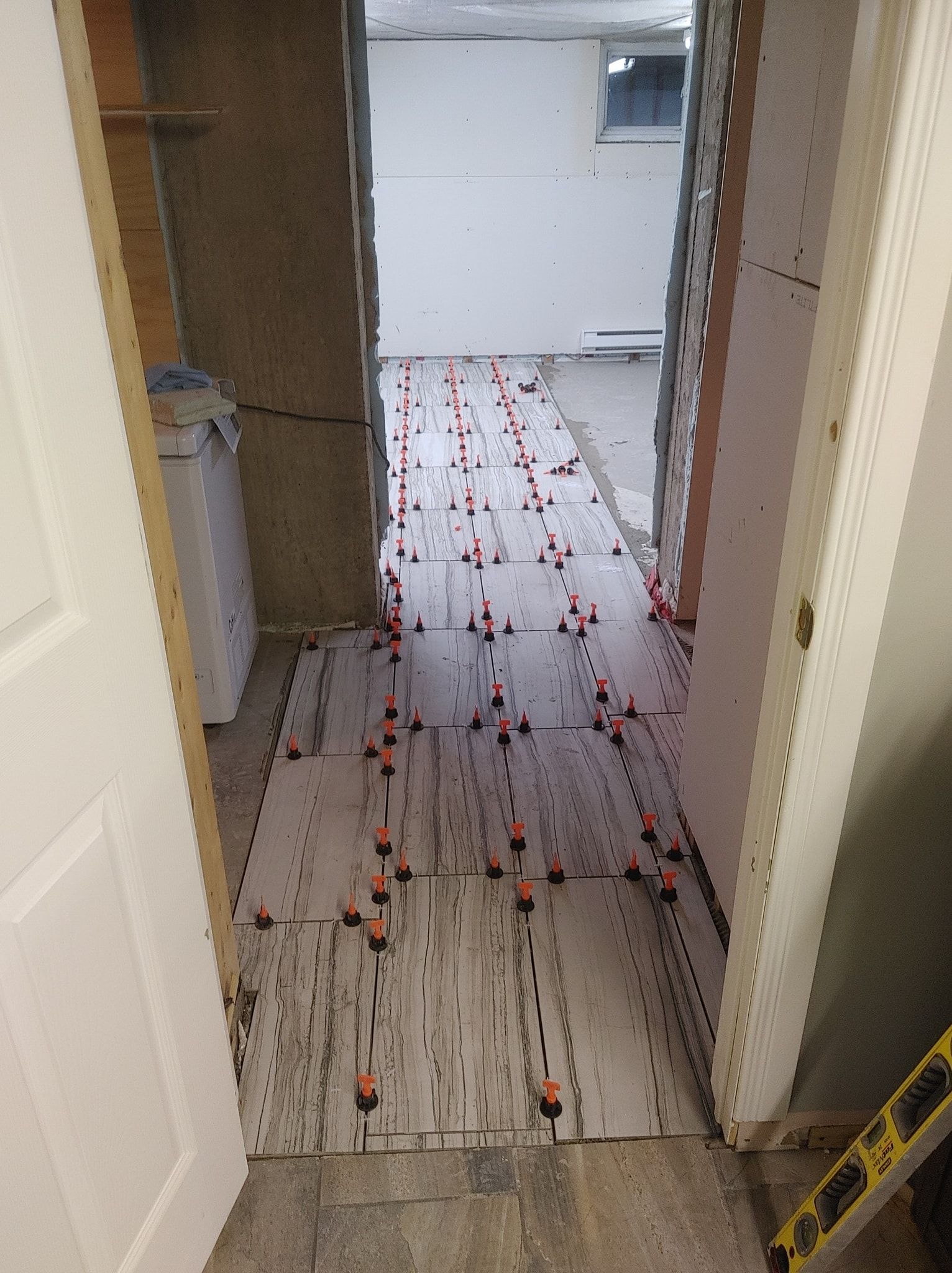 Un couloir avec un sol carrelé dans une maison en construction.