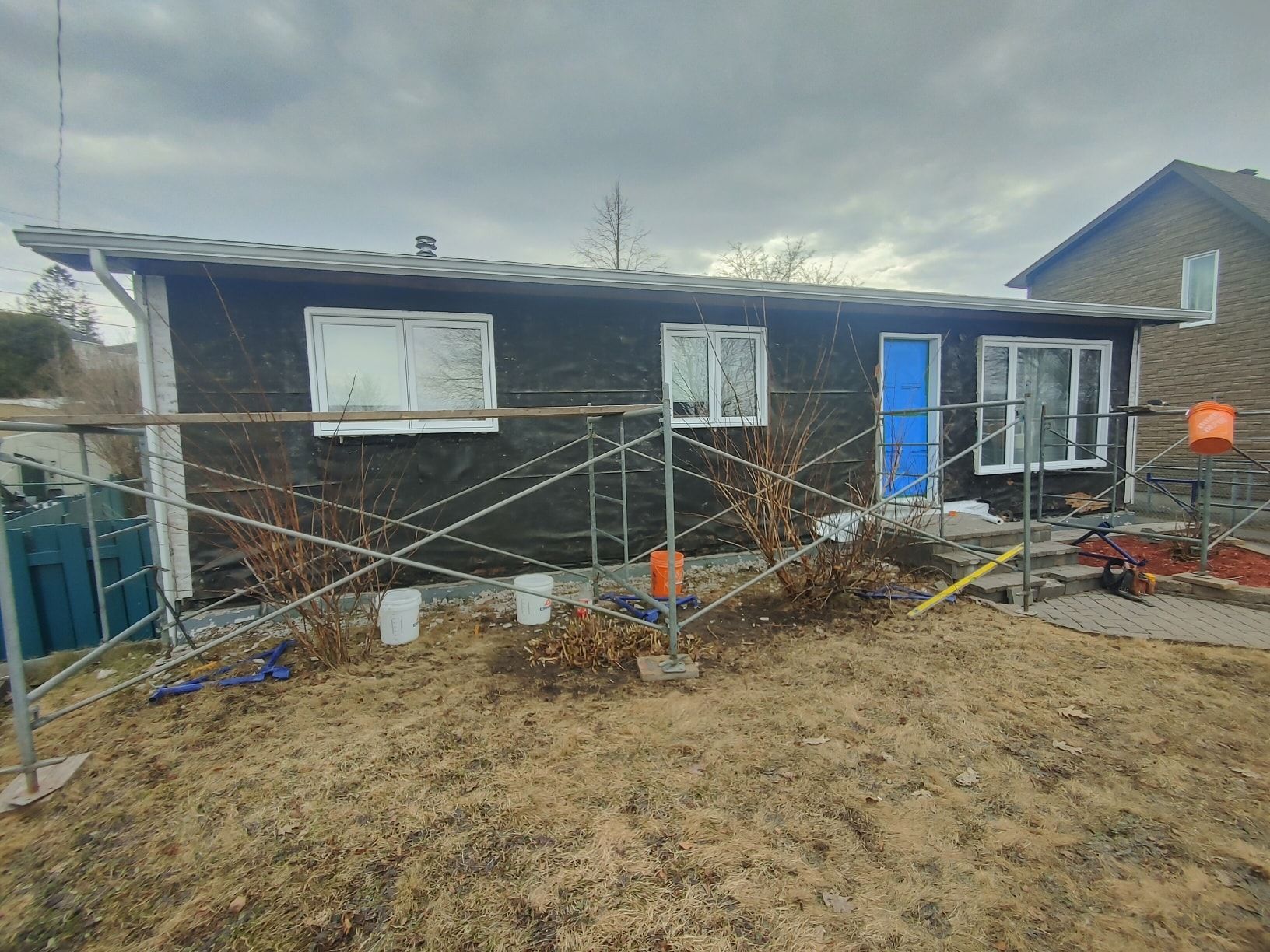 Une maison est en cours de rénovation avec un échafaudage devant elle.