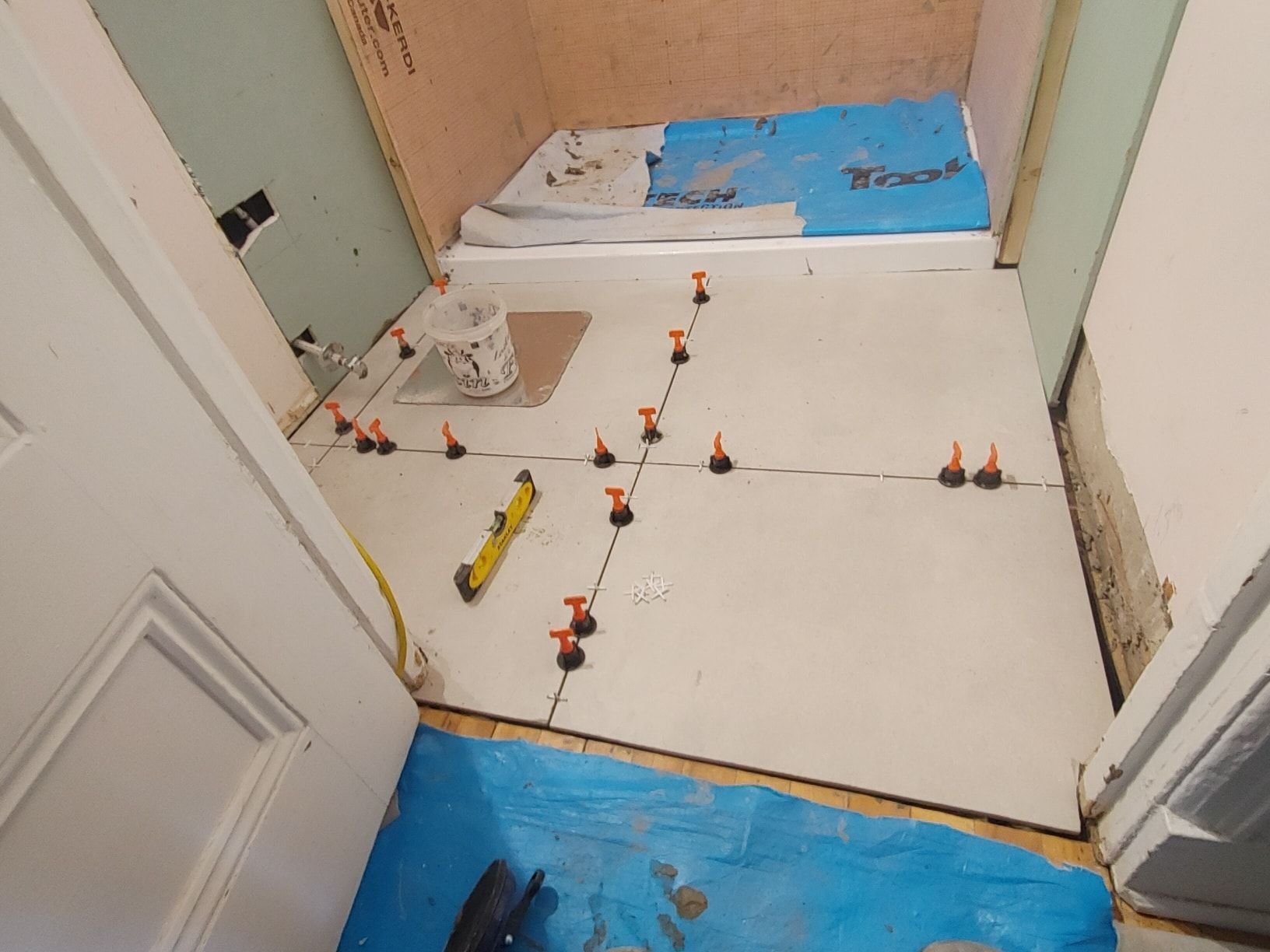 Un sol carrelé est en cours d'installation dans une salle de bain