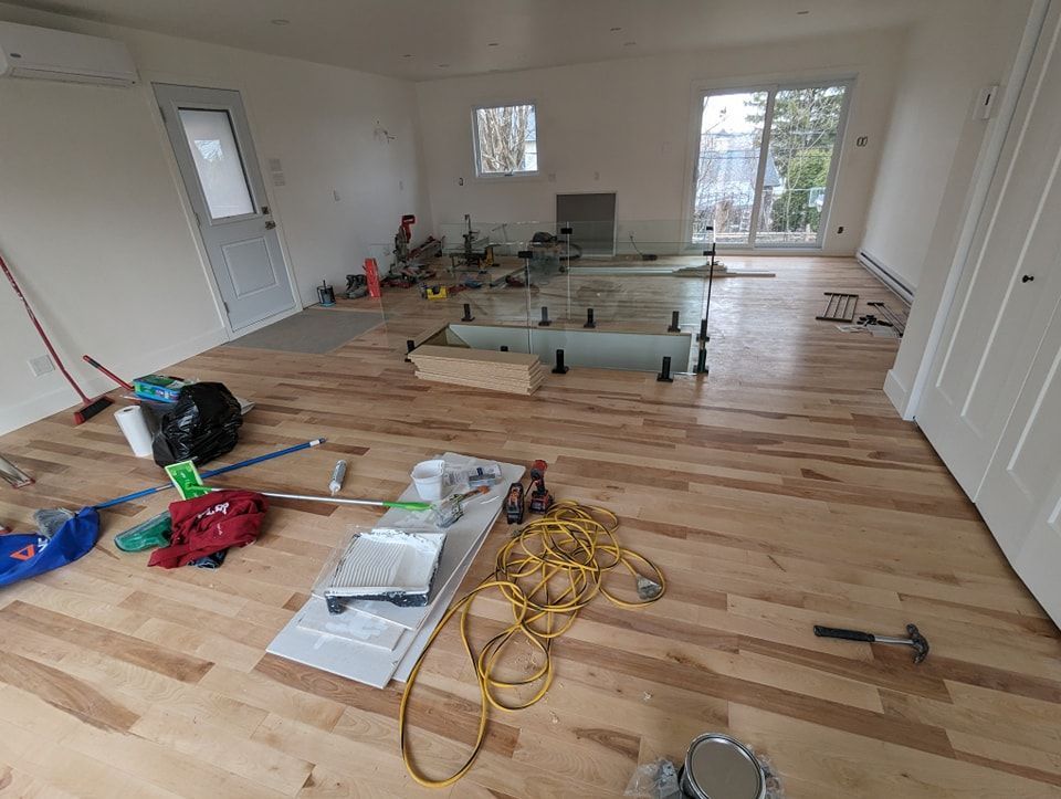 Une pièce avec du parquet et beaucoup d'outils sur le sol.