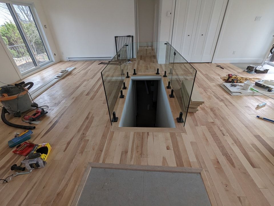 Un parquet dans une pièce avec un escalier et un aspirateur.