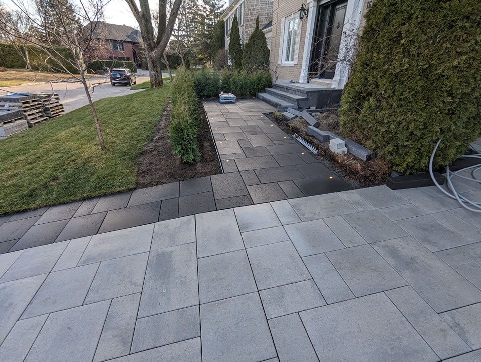 Une allée en briques menant à la porte d'entrée d'une maison.