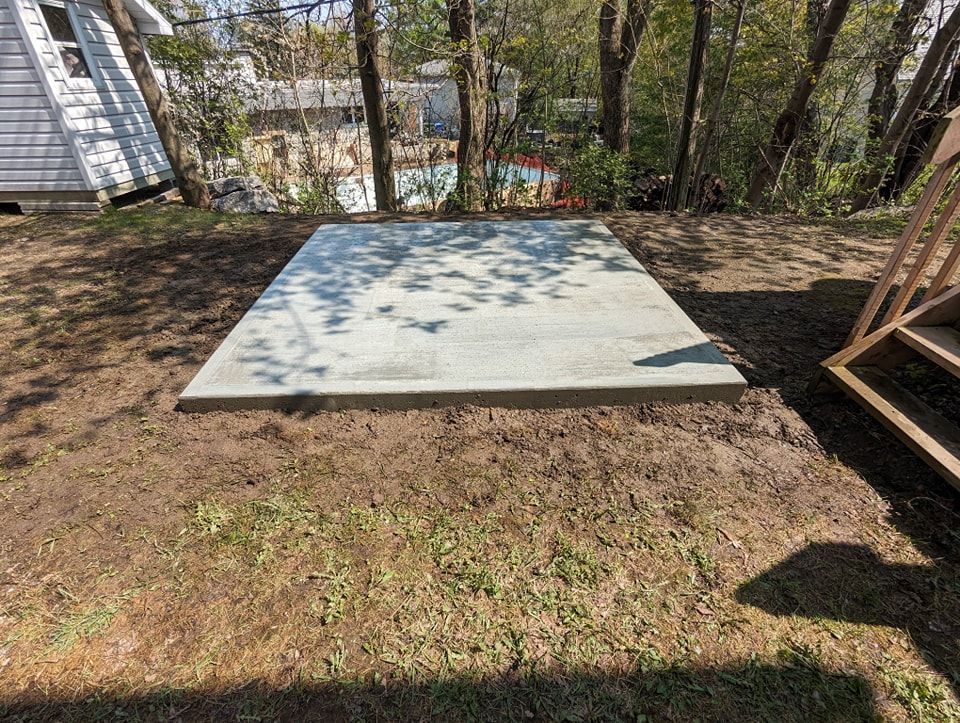 Une grande dalle de béton repose sur un champ vert luxuriant.