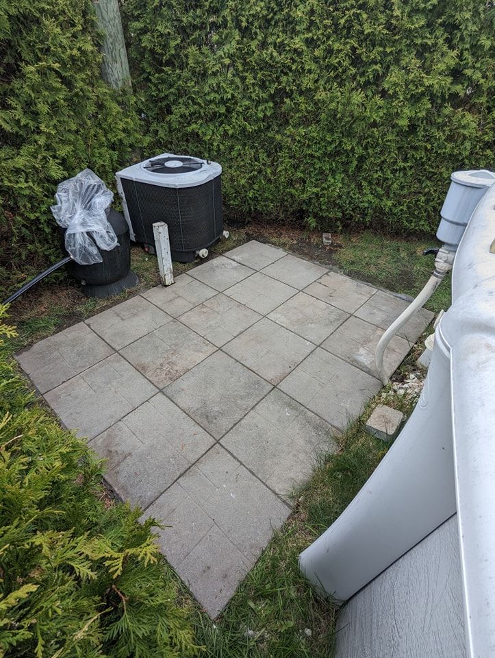 Un patio avec un chauffage et une poubelle dans la cour arrière.