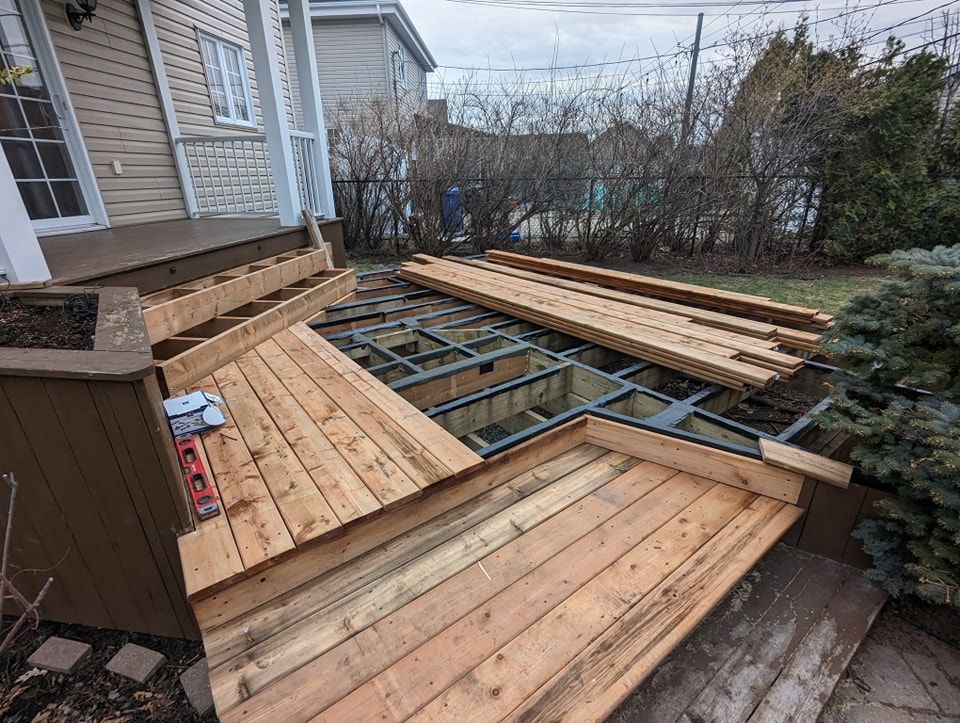 Une terrasse en bois est en cours de construction dans l'arrière-cour d'une maison.