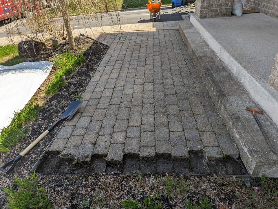 Une passerelle en briques est en cours de construction devant une maison.