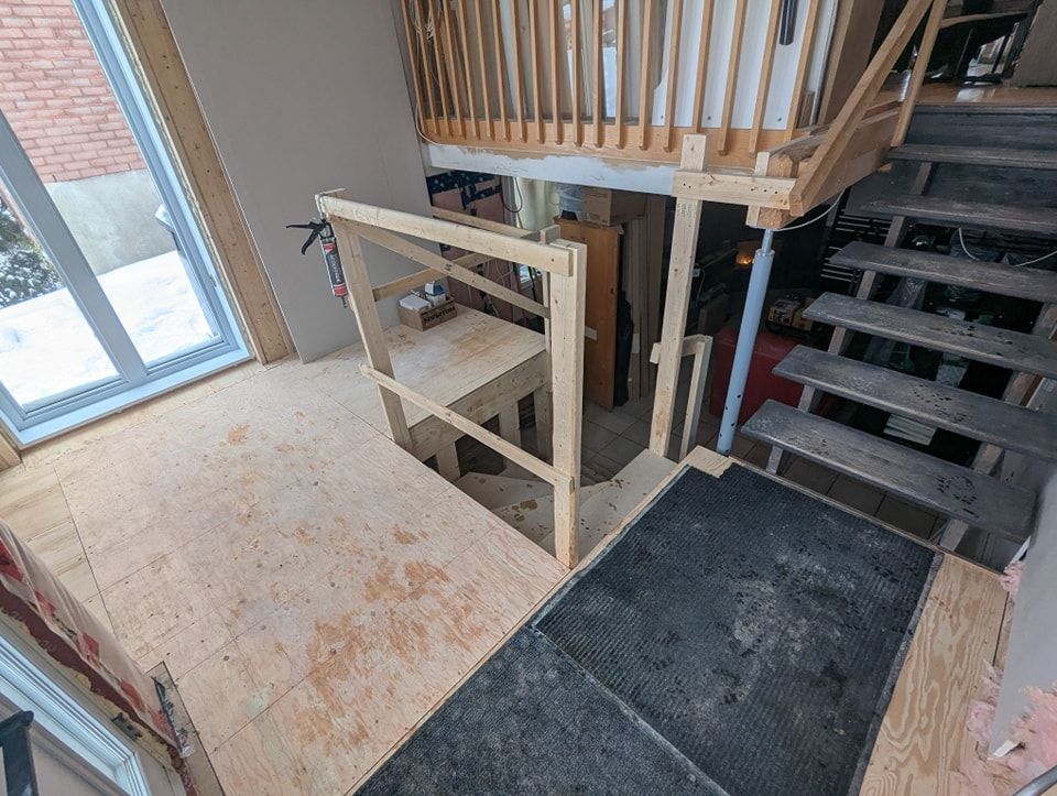 Un escalier en bois est en cours de construction dans une maison.