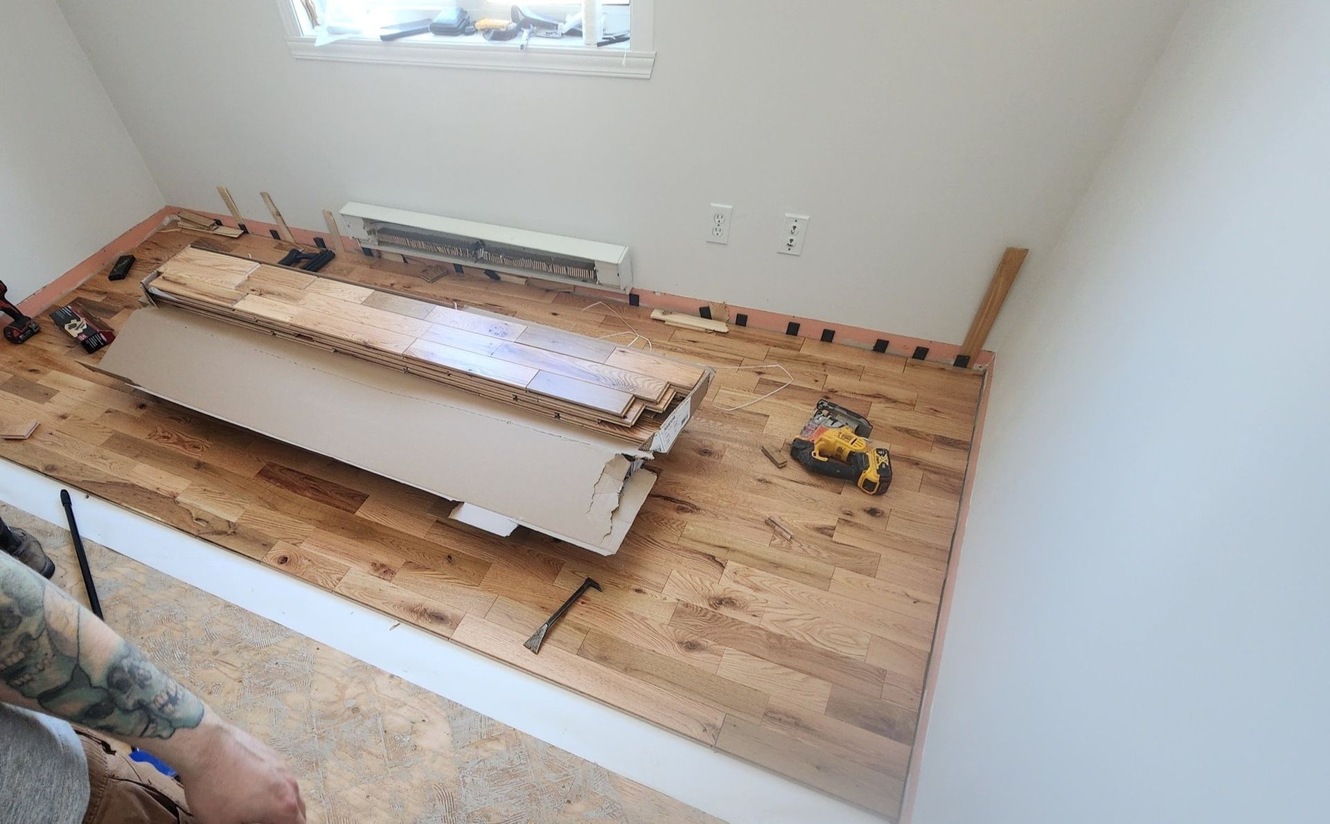 Une personne pose un parquet dans une pièce.