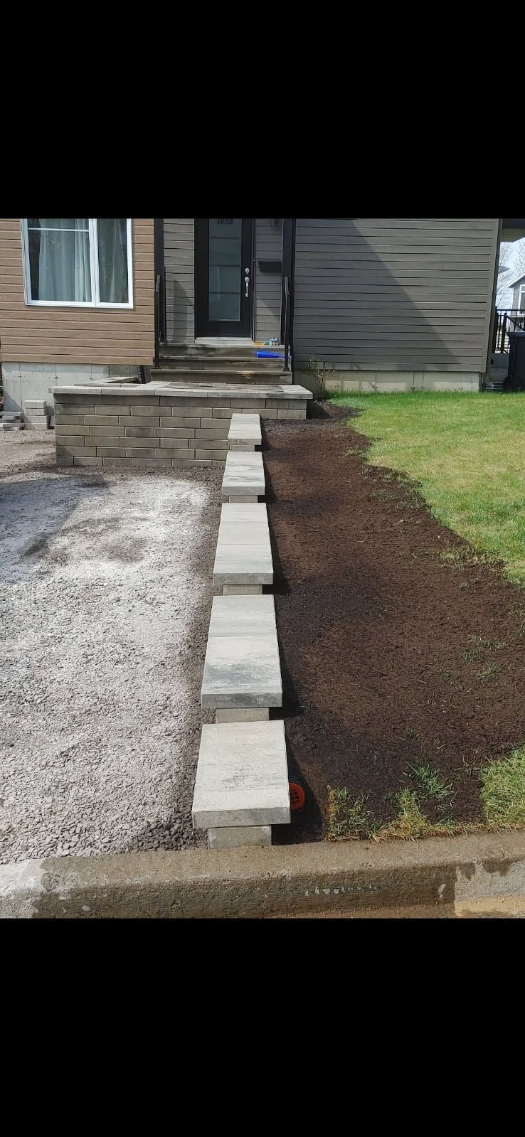 Une allée en pierre menant à la porte d'entrée d'une maison.