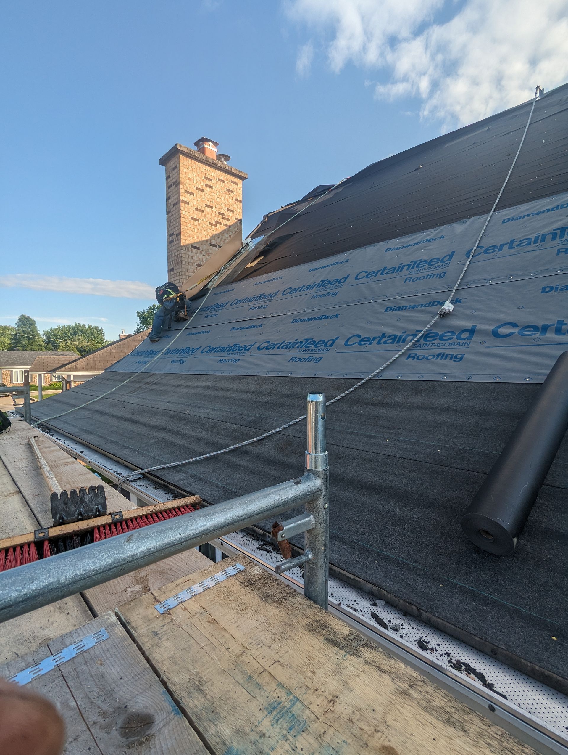 Une personne se tient sur un toit avec une cheminée en arrière-plan.