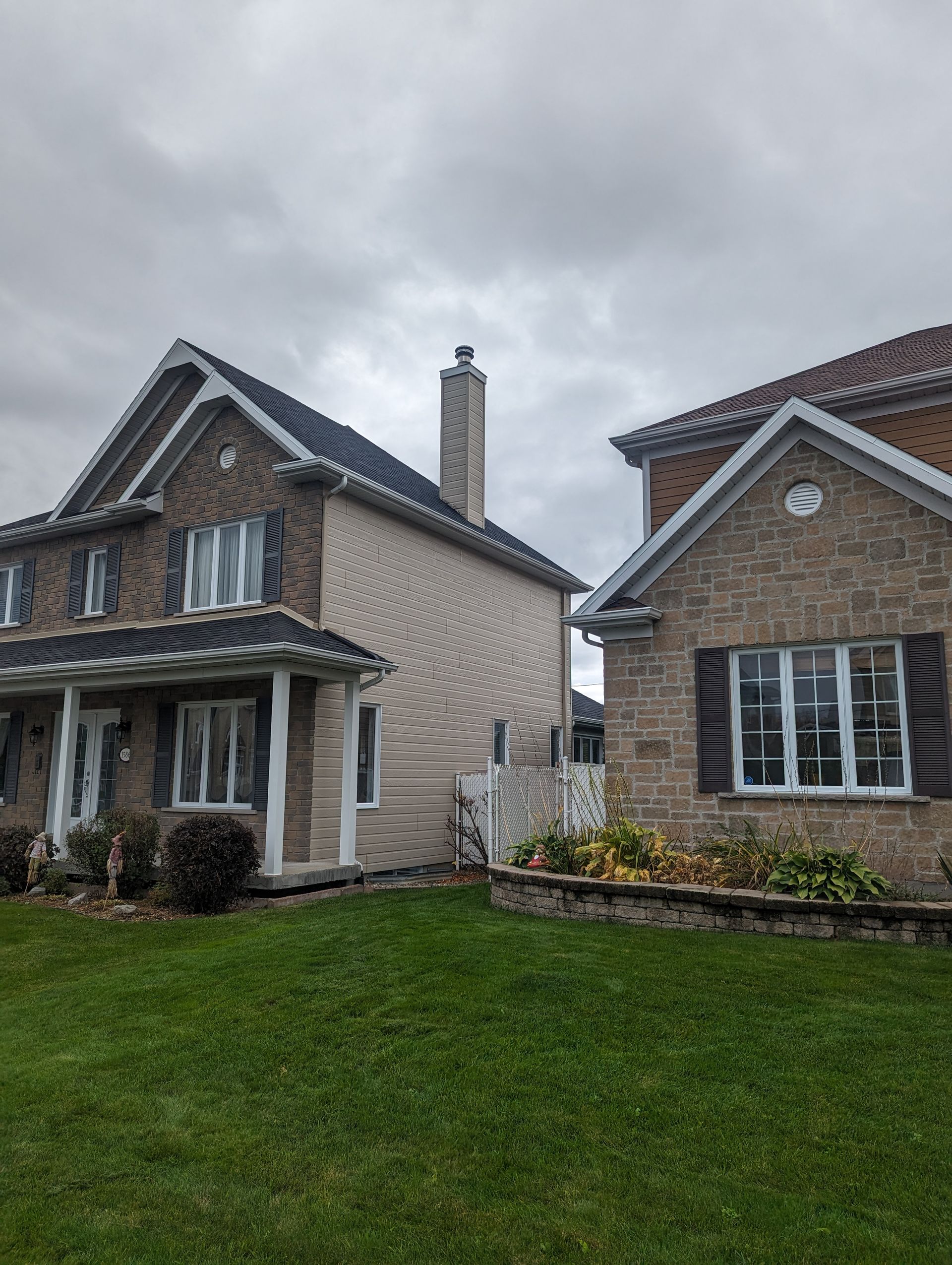 Deux maisons sont situées l'une à côté de l'autre sur une pelouse verte luxuriante.