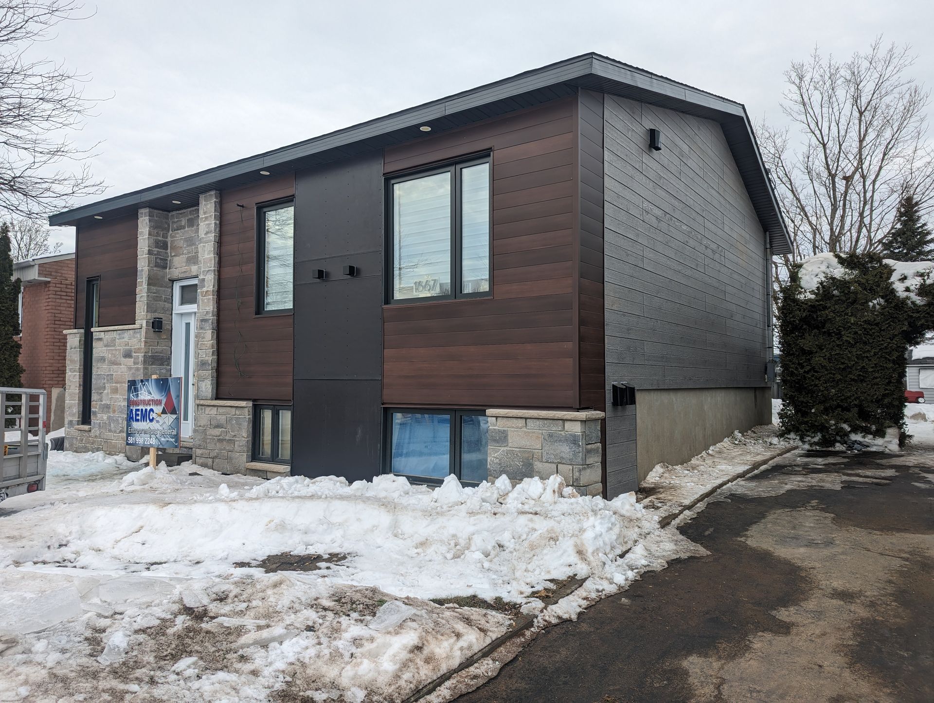 Une maison avec beaucoup de fenêtres est couverte de neige.