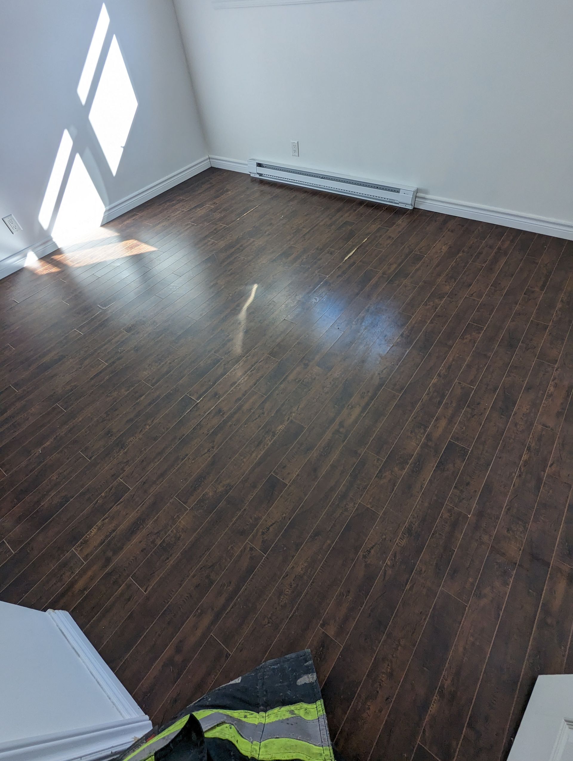 Une pièce avec un plancher en bois et des murs blancs.