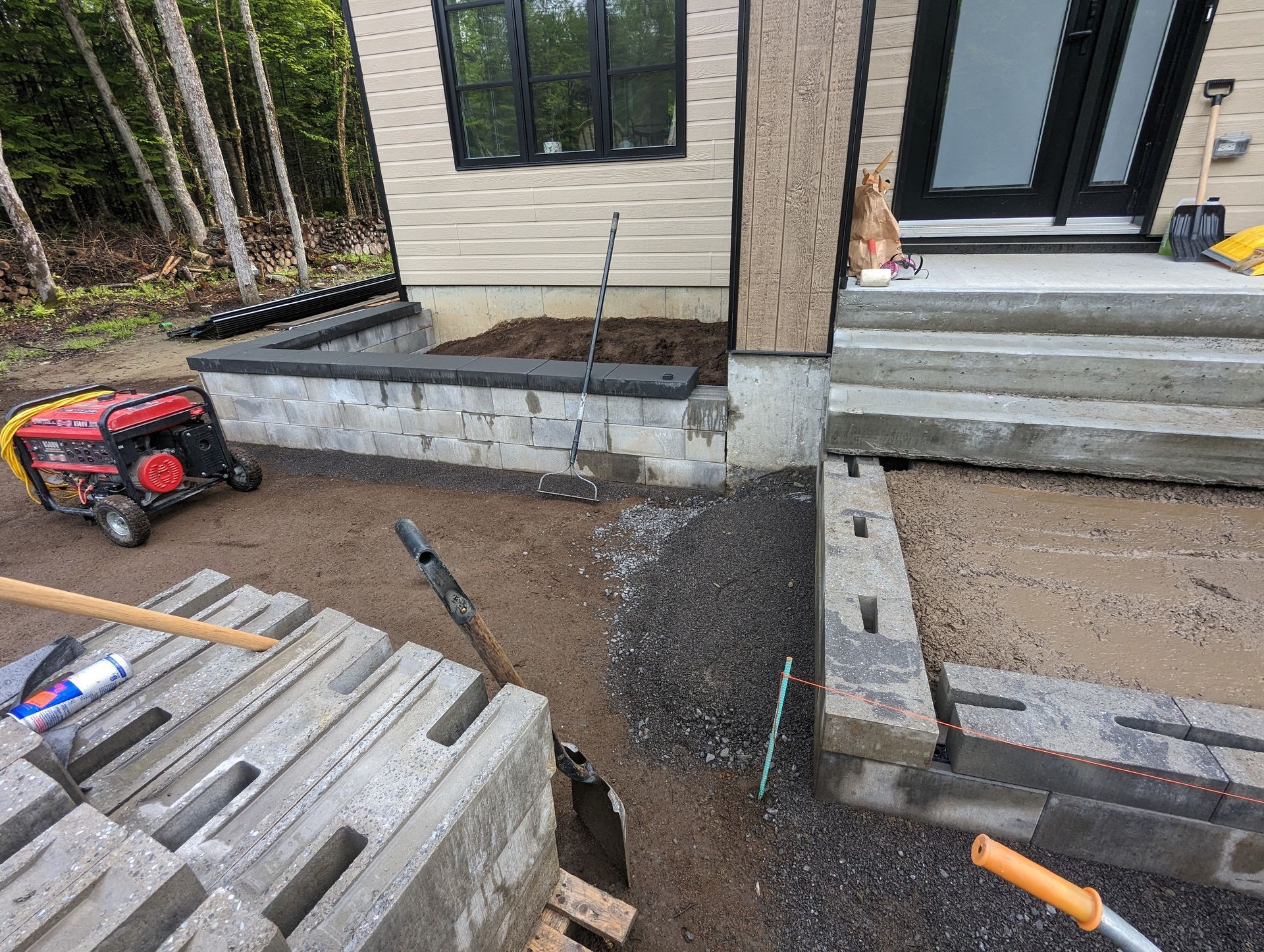 Un mur de briques est en train d'être construit devant une maison.