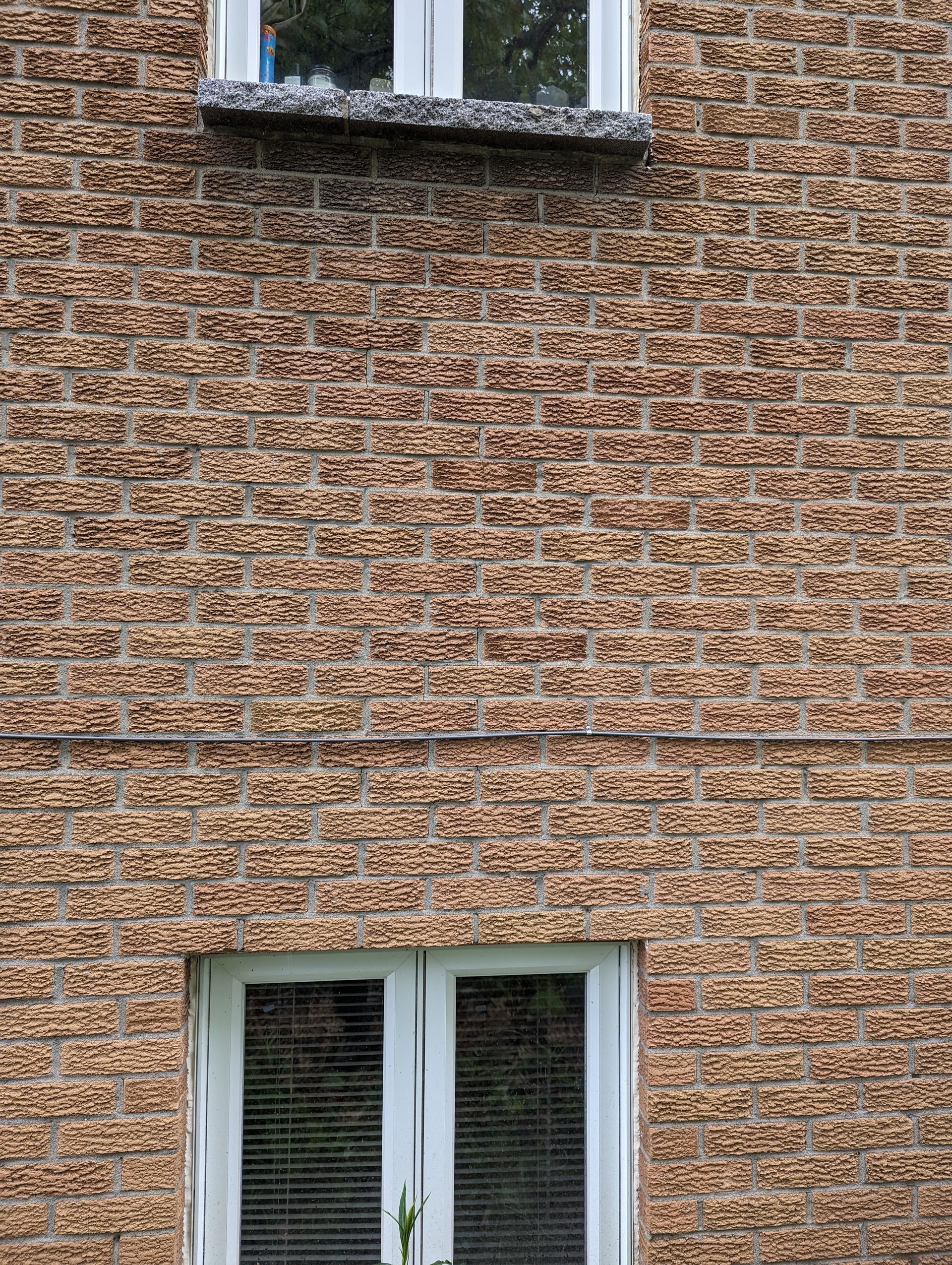 Un bâtiment en briques avec une fenêtre blanche sur le côté.