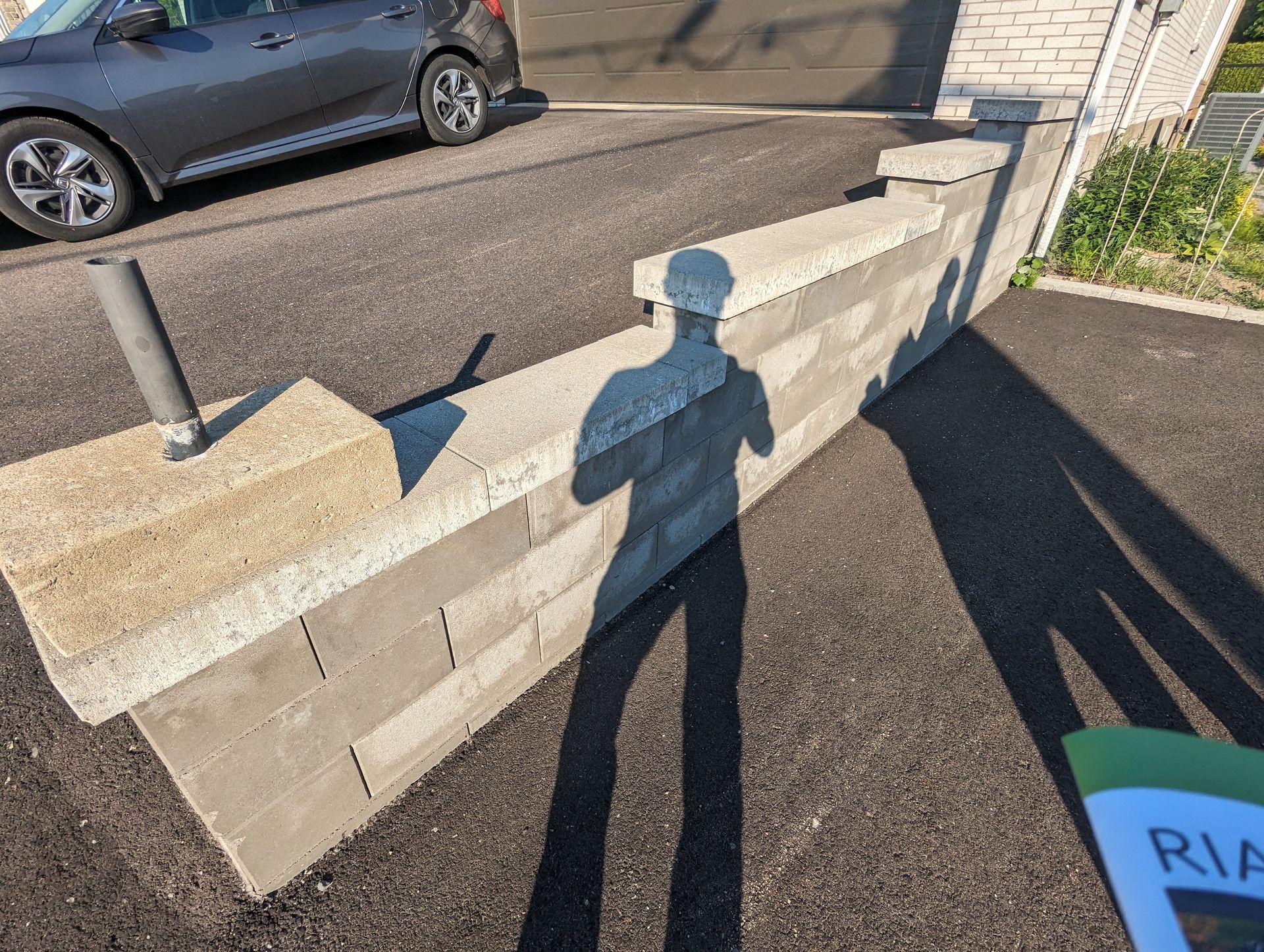 Une voiture est garée dans une allée à côté d'un mur de briques.