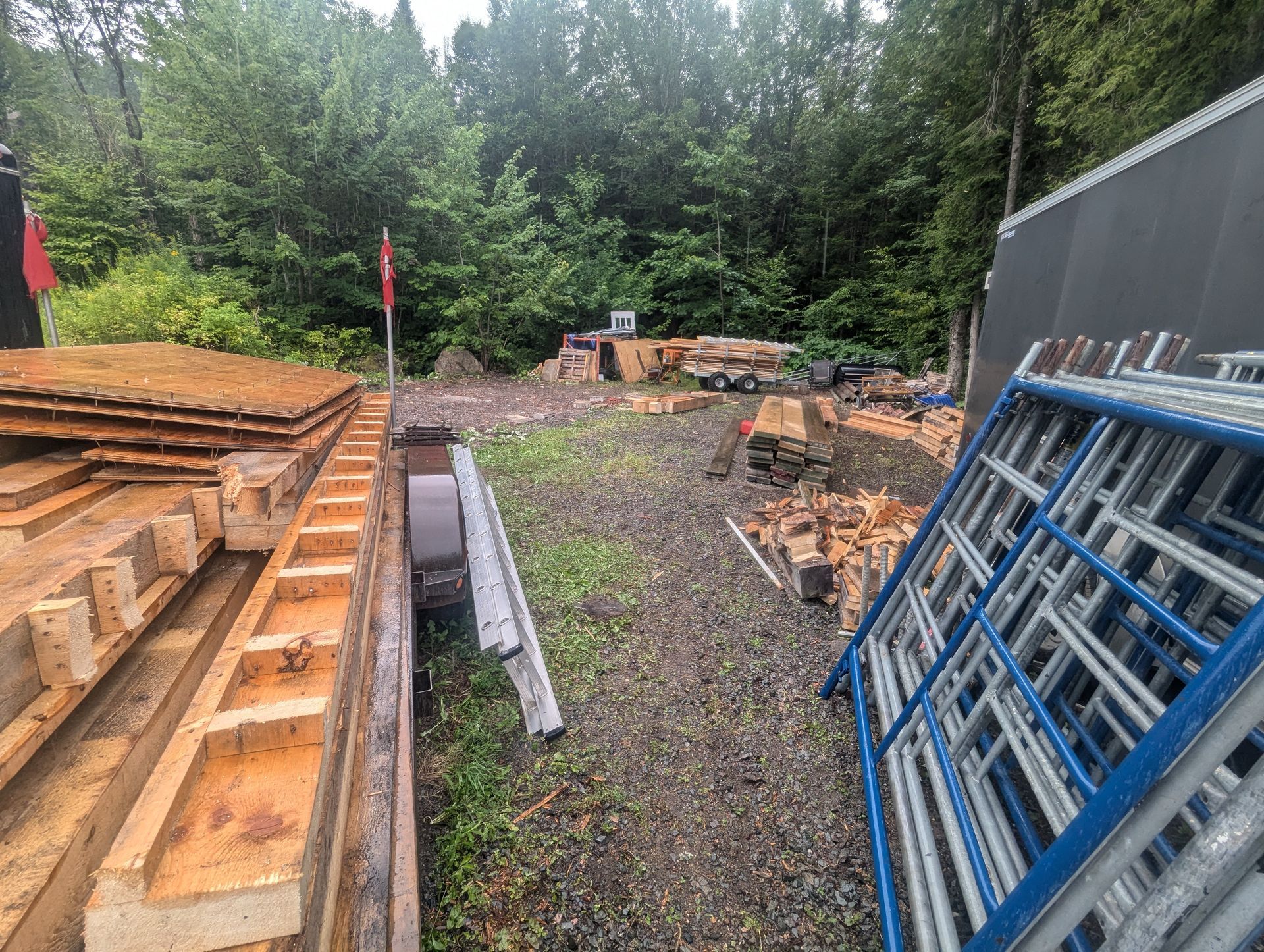 Un tas de palettes en bois sont empilées les unes sur les autres dans une cour.