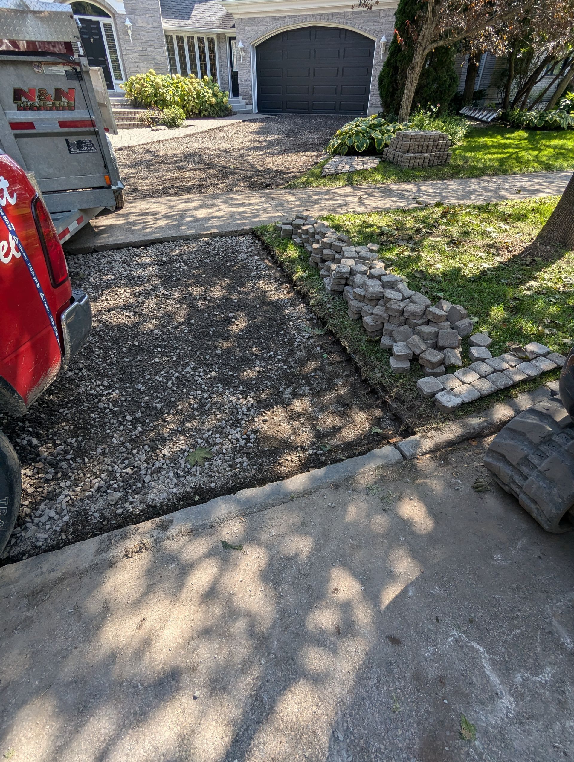 Une allée en béton est en cours de construction devant une maison.
