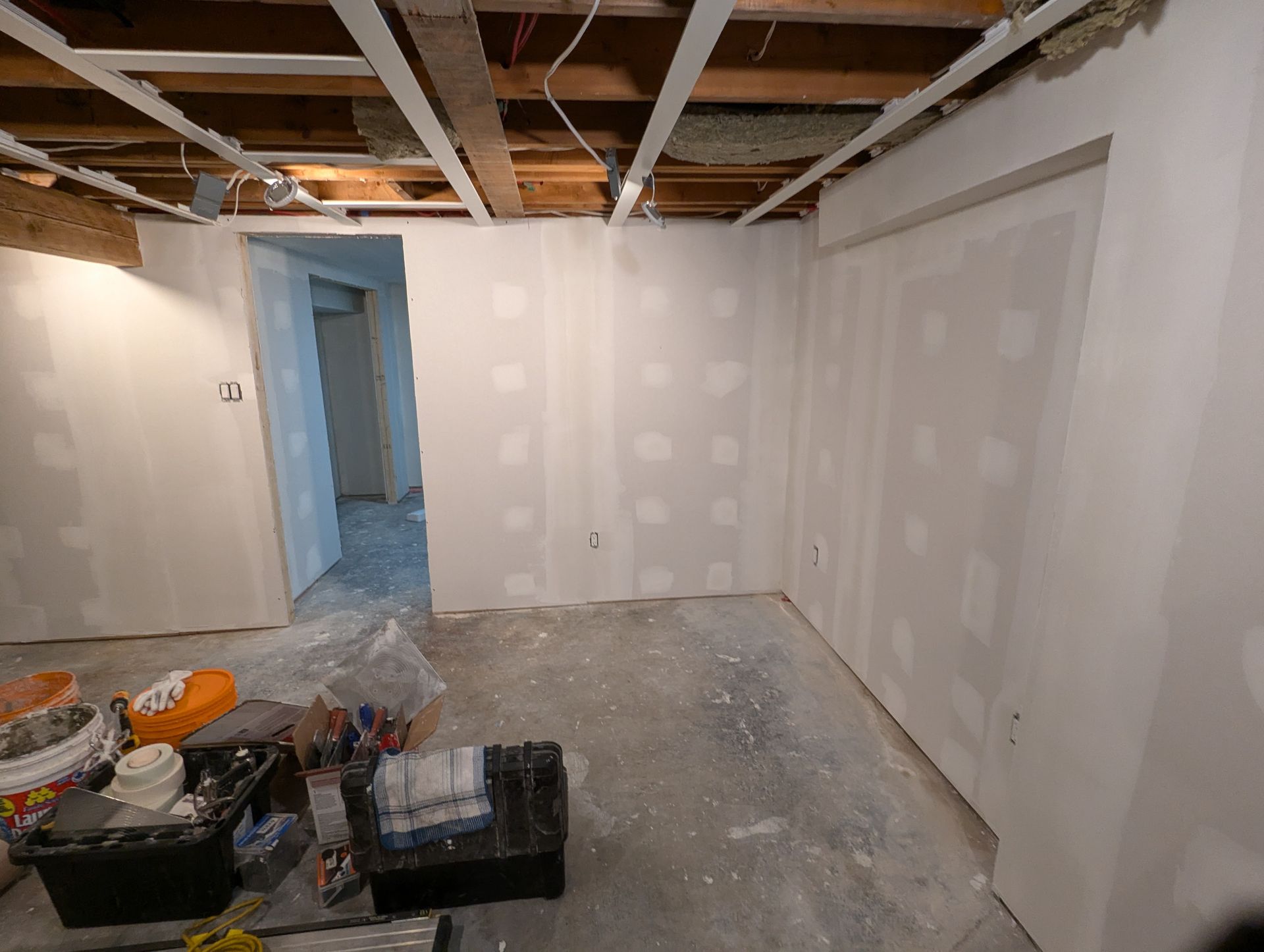 Une pièce aux murs blancs et au plafond en bois est en cours de rénovation.