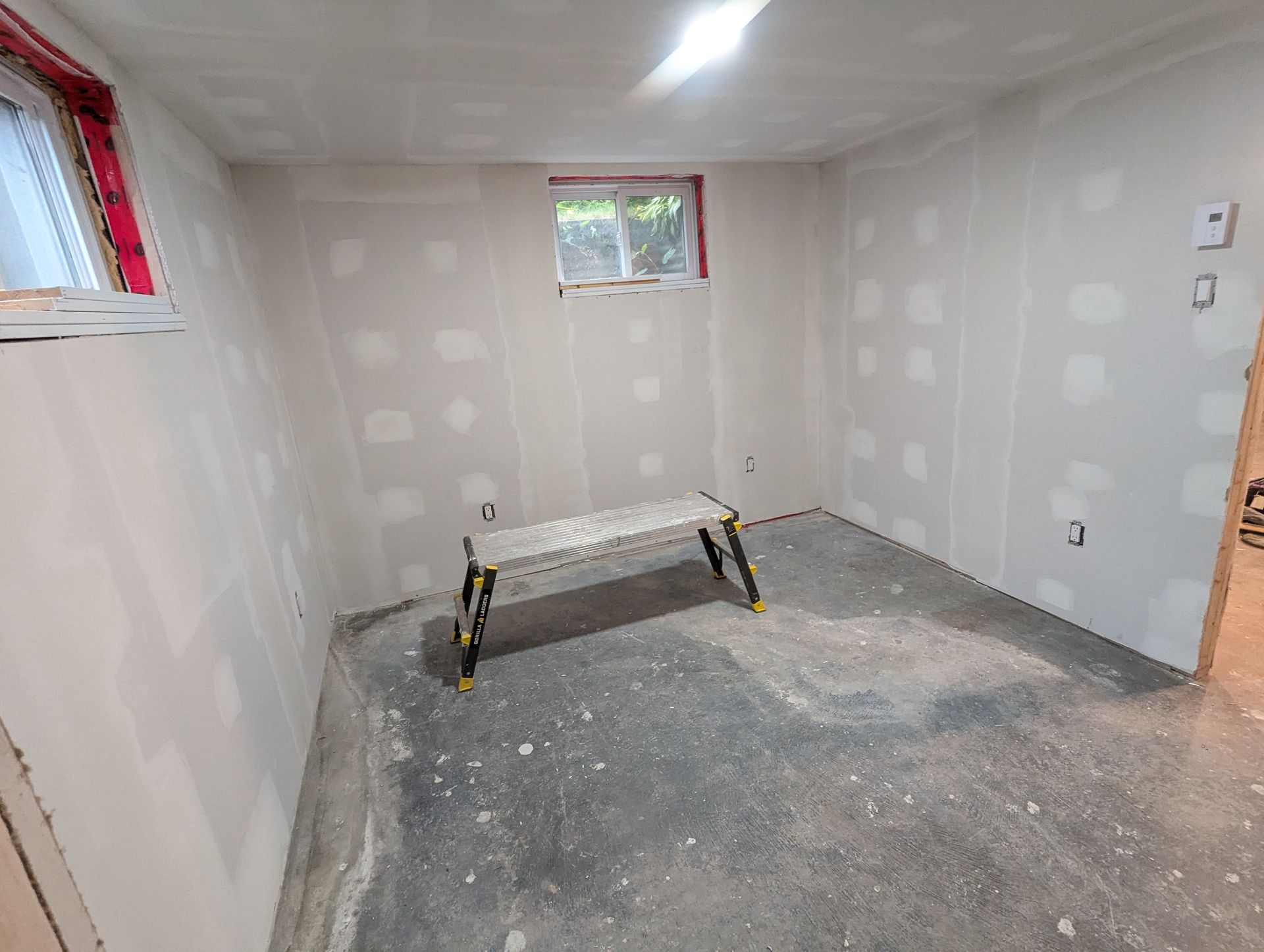 Une pièce avec des murs en plaques de plâtre et un banc à l'intérieur.