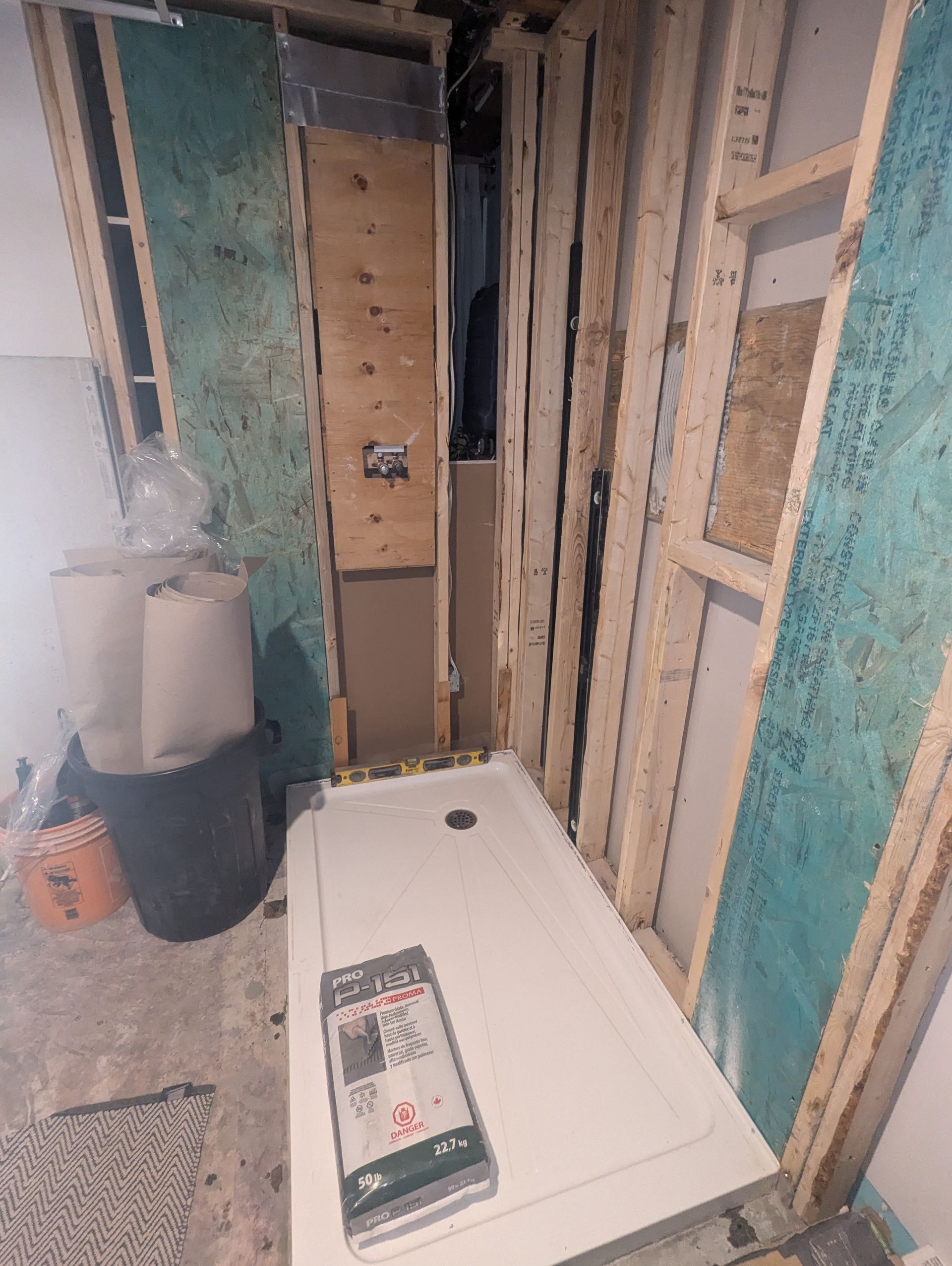 Une cabine de douche est en cours de construction dans une salle de bain en construction.