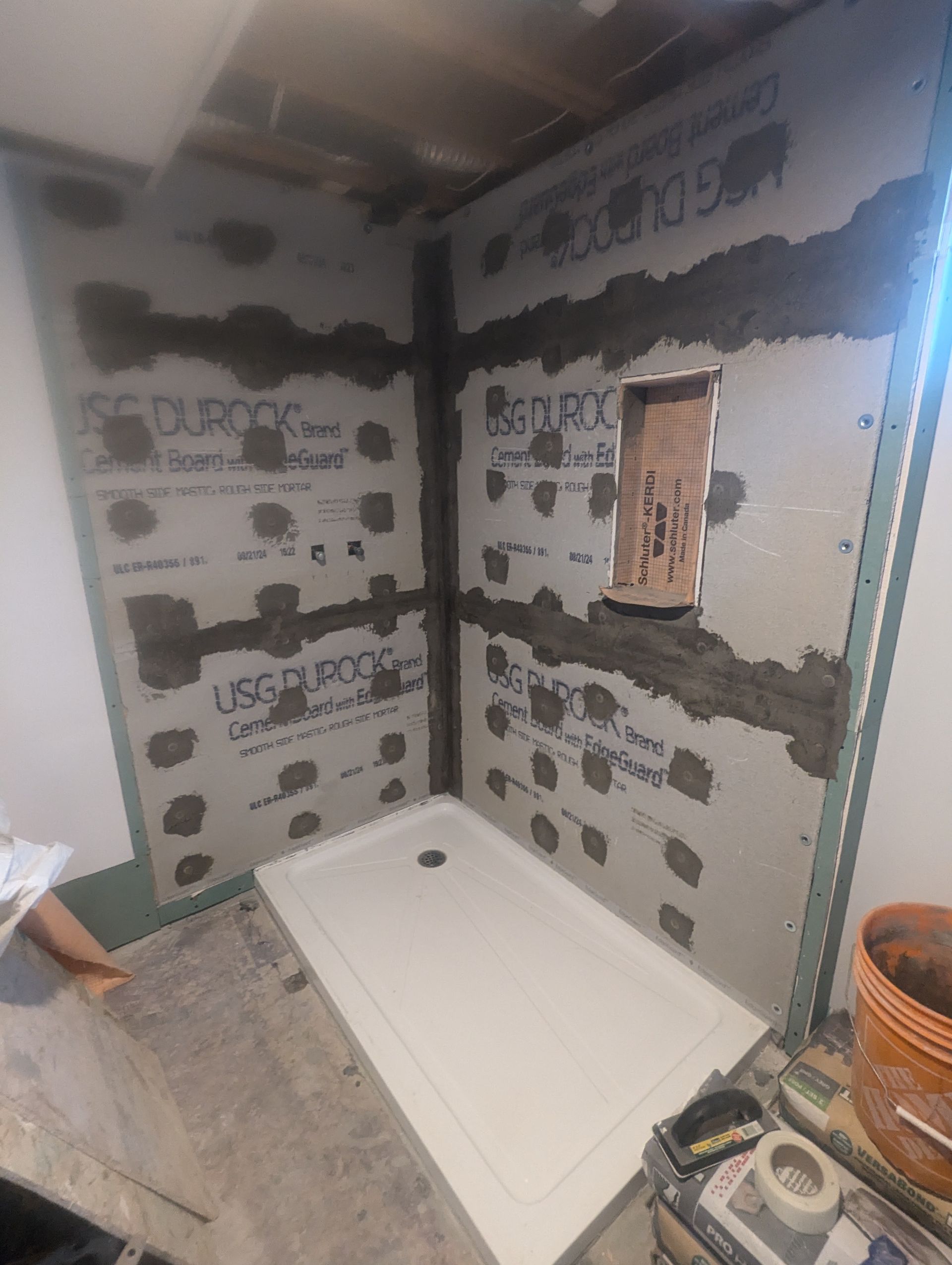 Une salle de bain est en cours de rénovation et une cabine de douche est en cours d'installation.